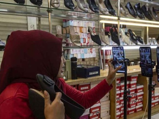 Pedagang menawarkan sepatu secara daring melalui siaran langsung di Pasar Tanah Abang, Jakarta, Selasa (13/6/2023).