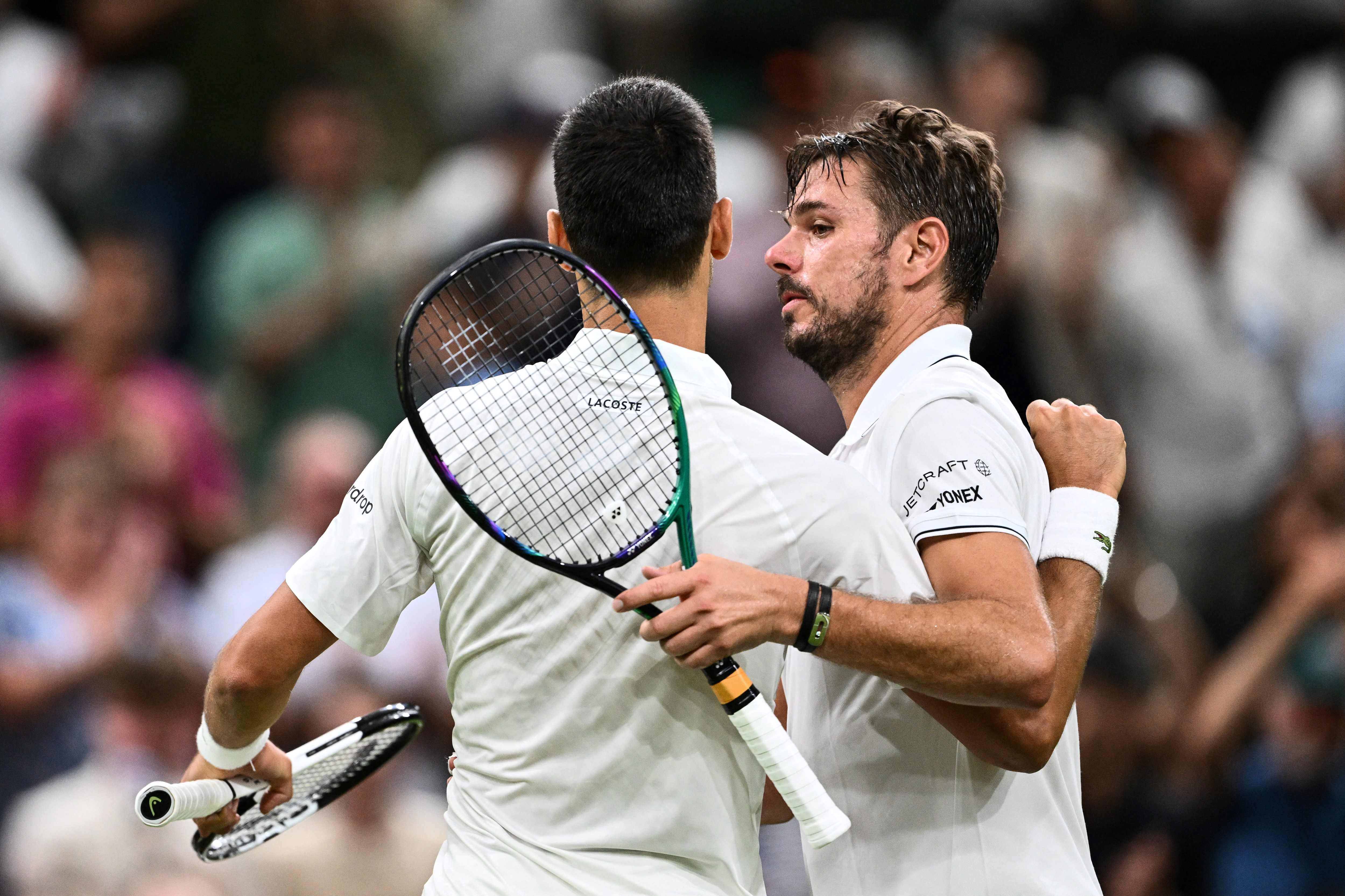 Petenis Serbia Novak Djokovic (kiri) dan petenis Swiss Stan Wawrinka berpelukan usai laga putaran kedua Wimbledon.