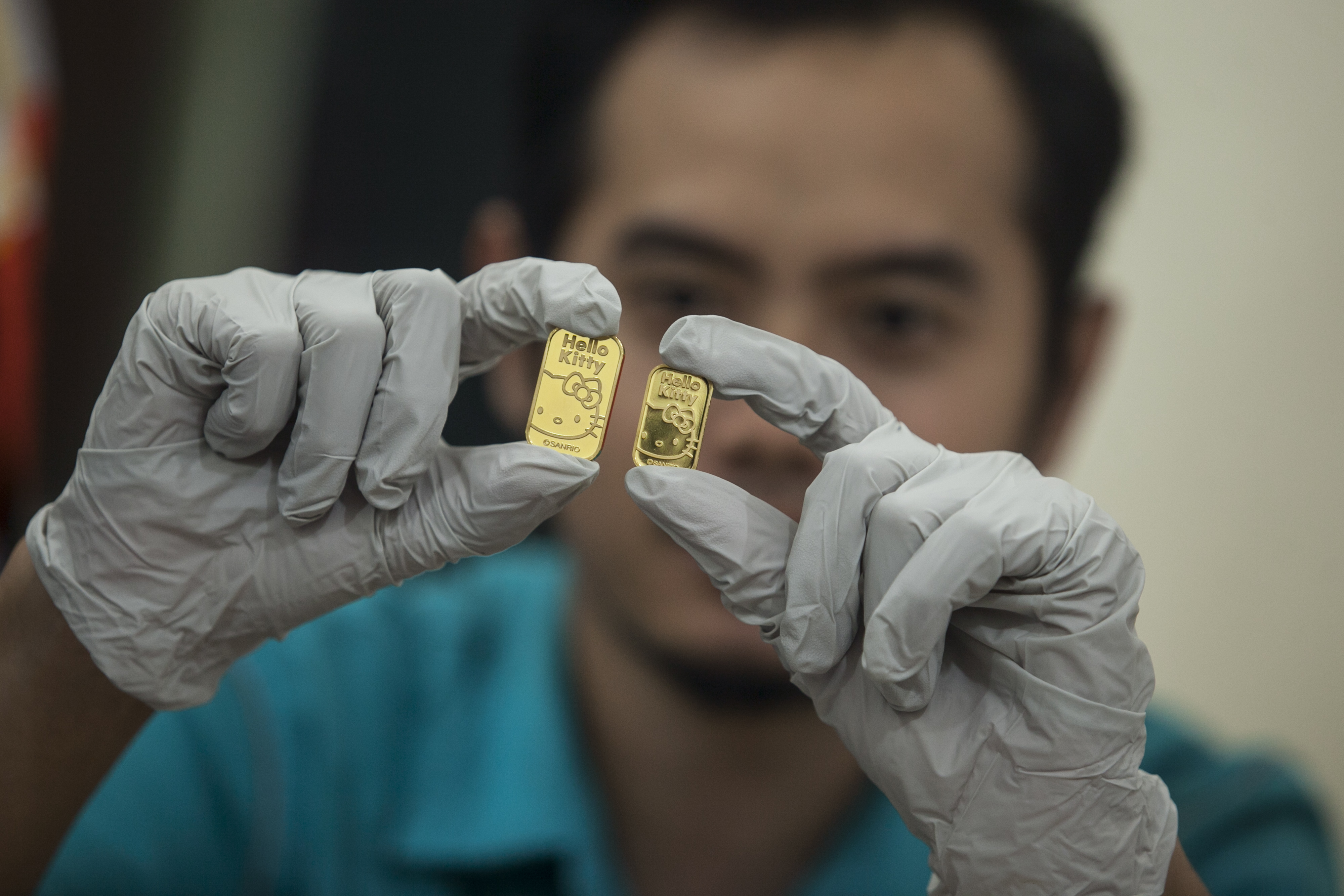 Petugas menunjukkan produk emas motif Hello Kitty sebelum didistribusikan ke Jepang di PT Antam TBK UBPP LM, Pulogadung, Jakarta.