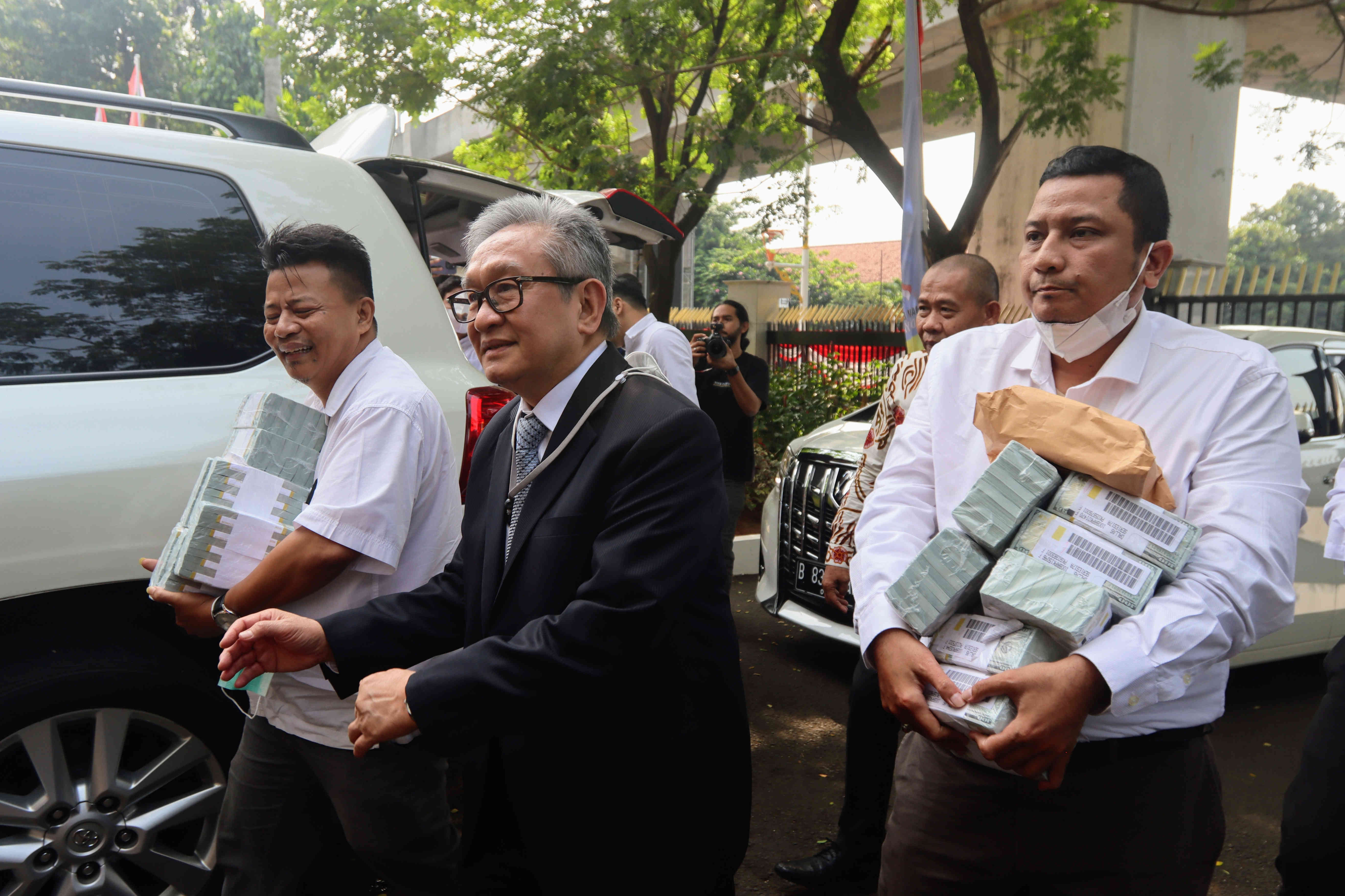 Maqdir Ismail (jas hitam) pengacara dari Irwan Hermawan dalam kasus korupsi BTS Bakti Kominfo, membawa uang sebesar Rp27 miliar ke Kejagung.