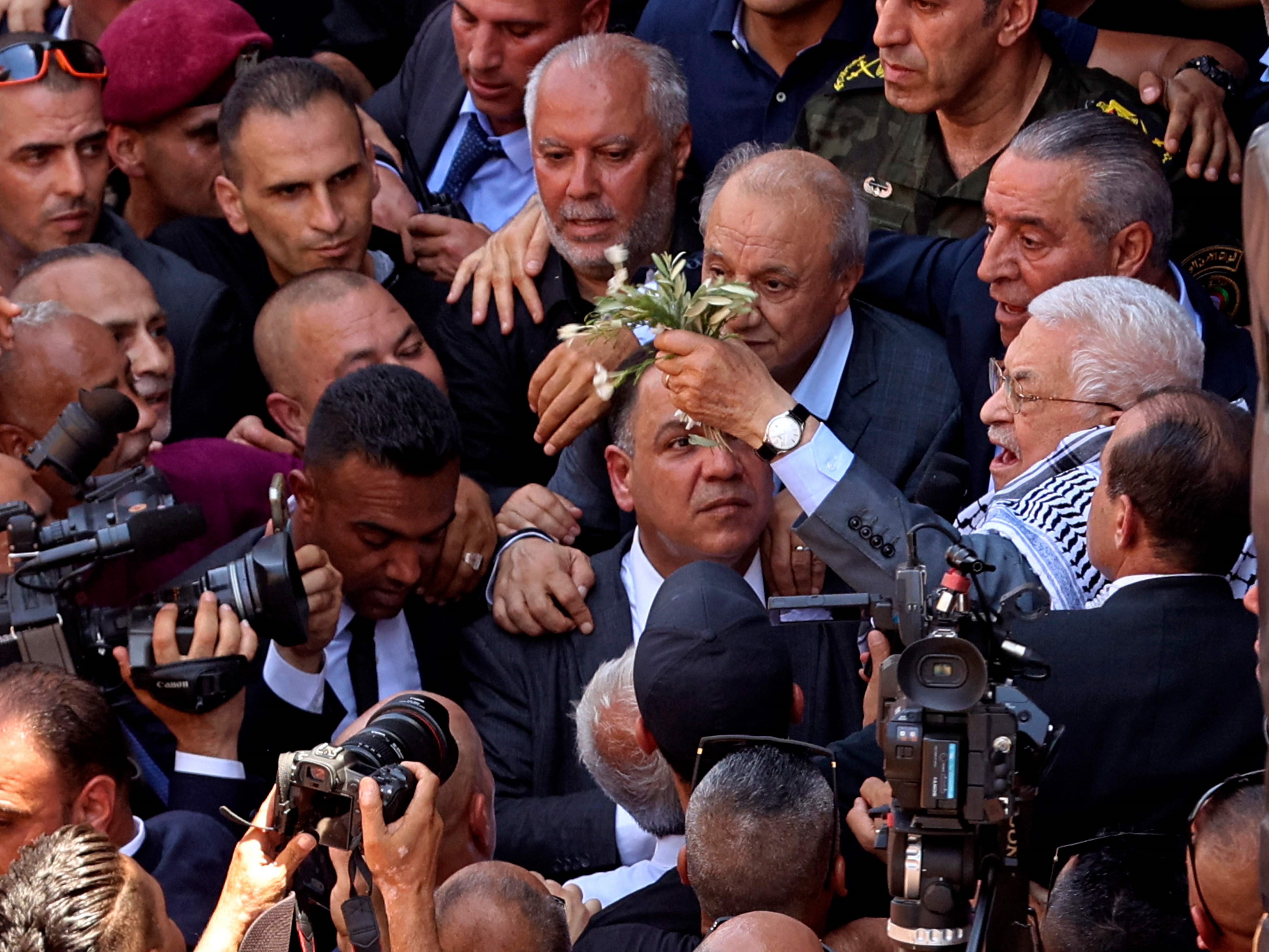 Presiden Palestina Mahmud Abbas (kanan) tiba untuk meletakkan karangan bunga di dekat kuburan warga Palestina yang terbunuh.