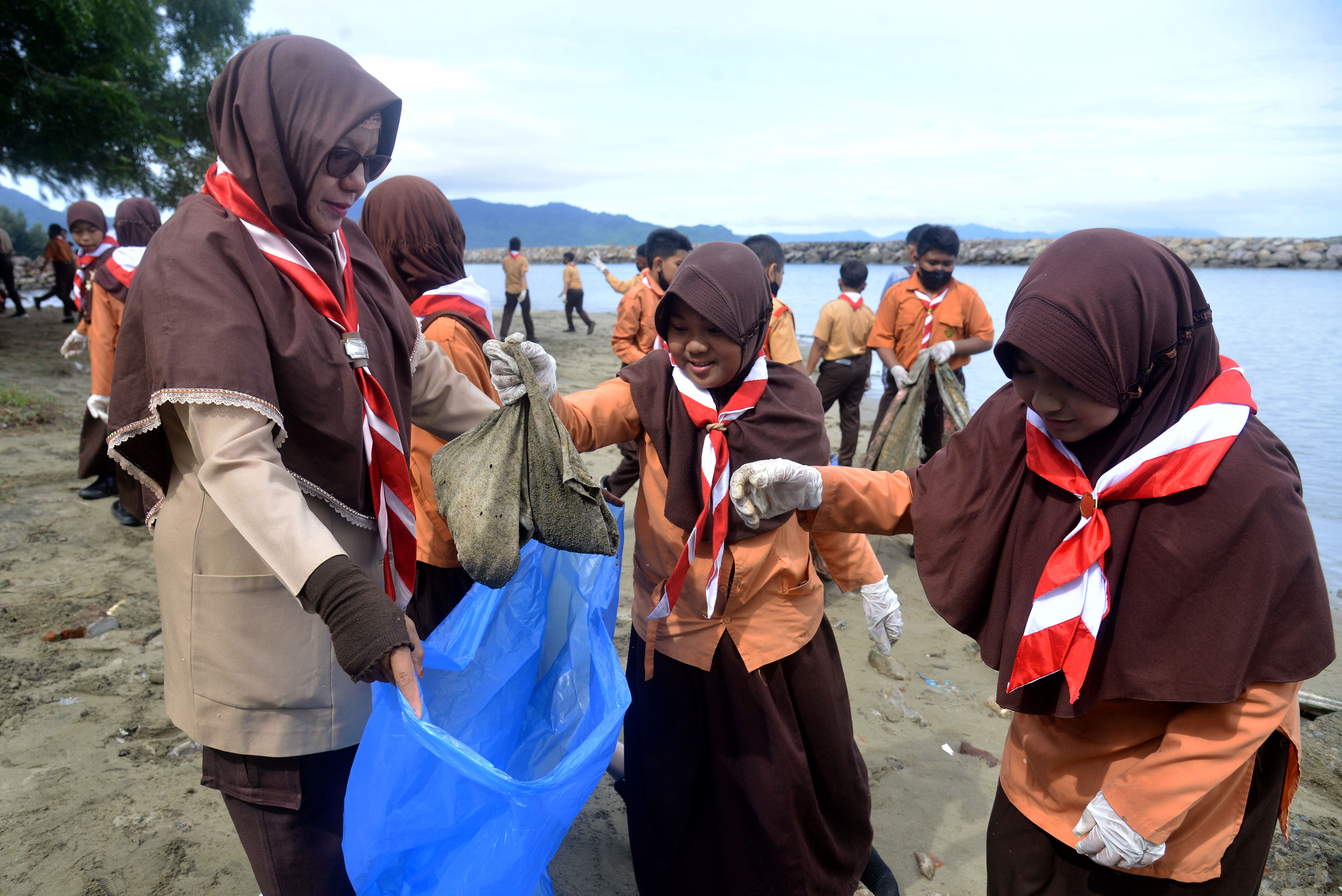 Anggota pramuka memungut berbagai jenis sampah plastik di pantai wisata Ulee Lheue, Banda Aceh, Aceh.