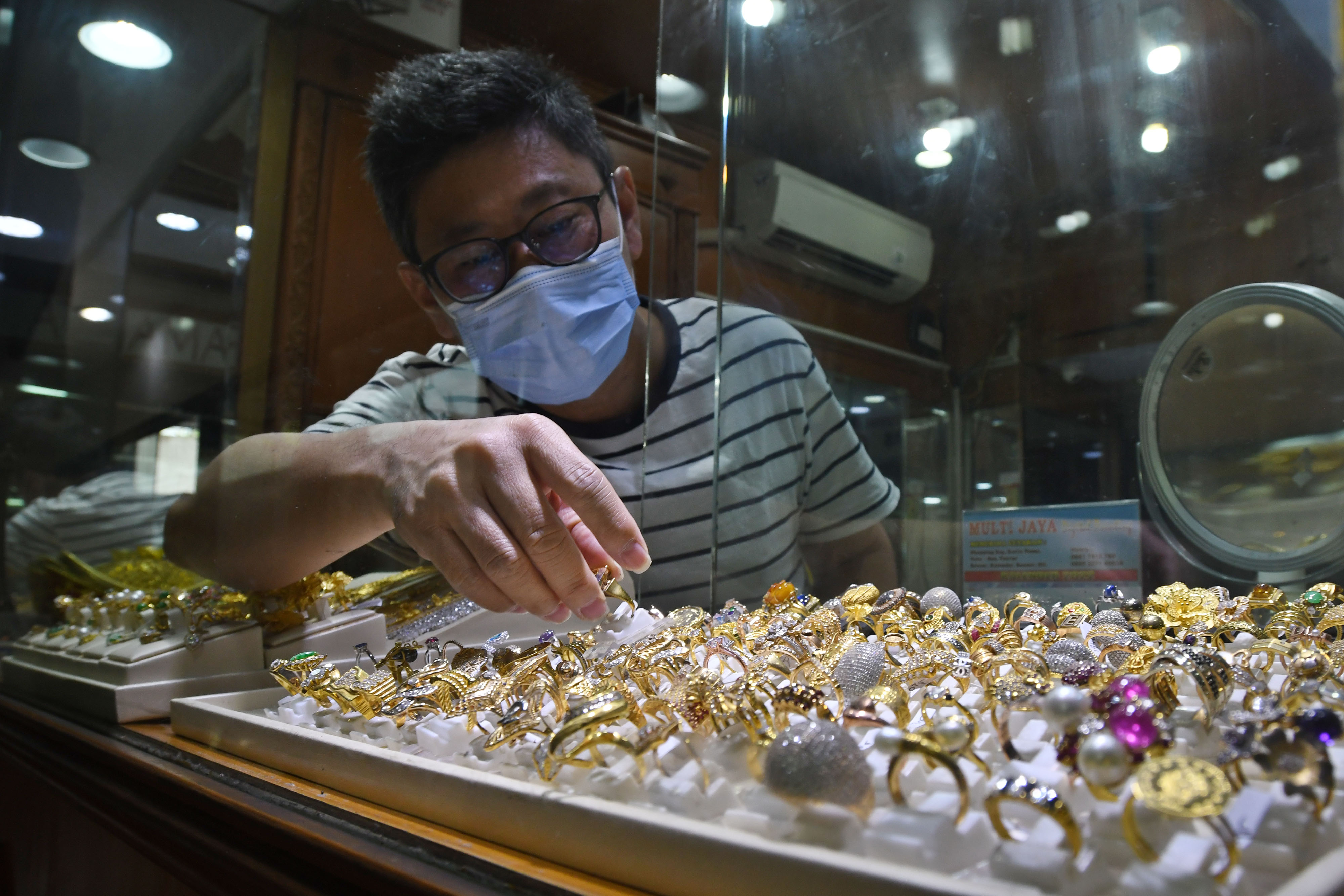 Pedagang mengambil emas yang dipilih calon pembeli