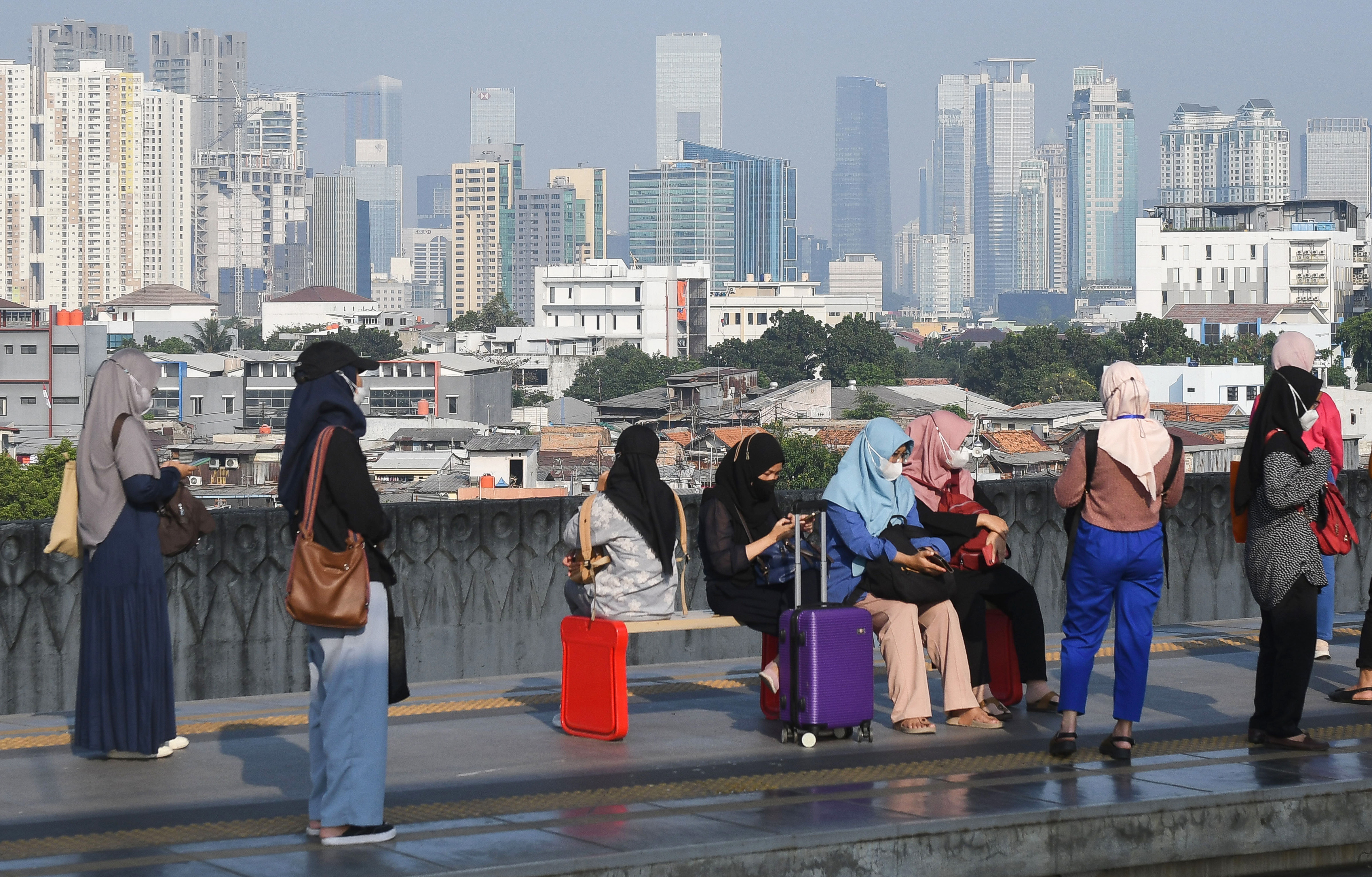  Sejumlah warga mengenakan masker saat berada di Stasiun KA Manggarai