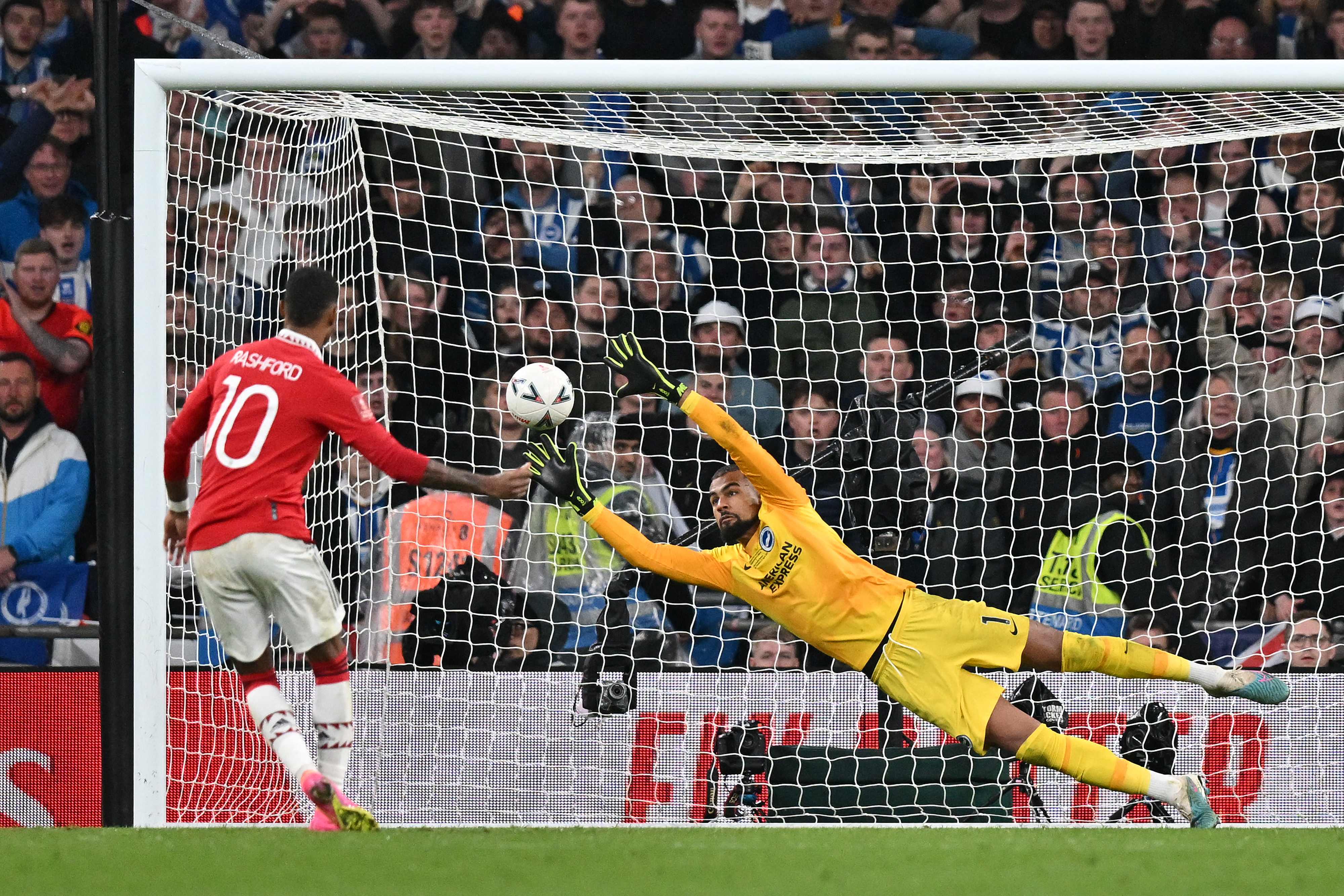 Kiper Brighton Robert Sanchez (kanan) mencoba menggagalkan tendangan penalti pemain Manchester United Marcus Rashford.