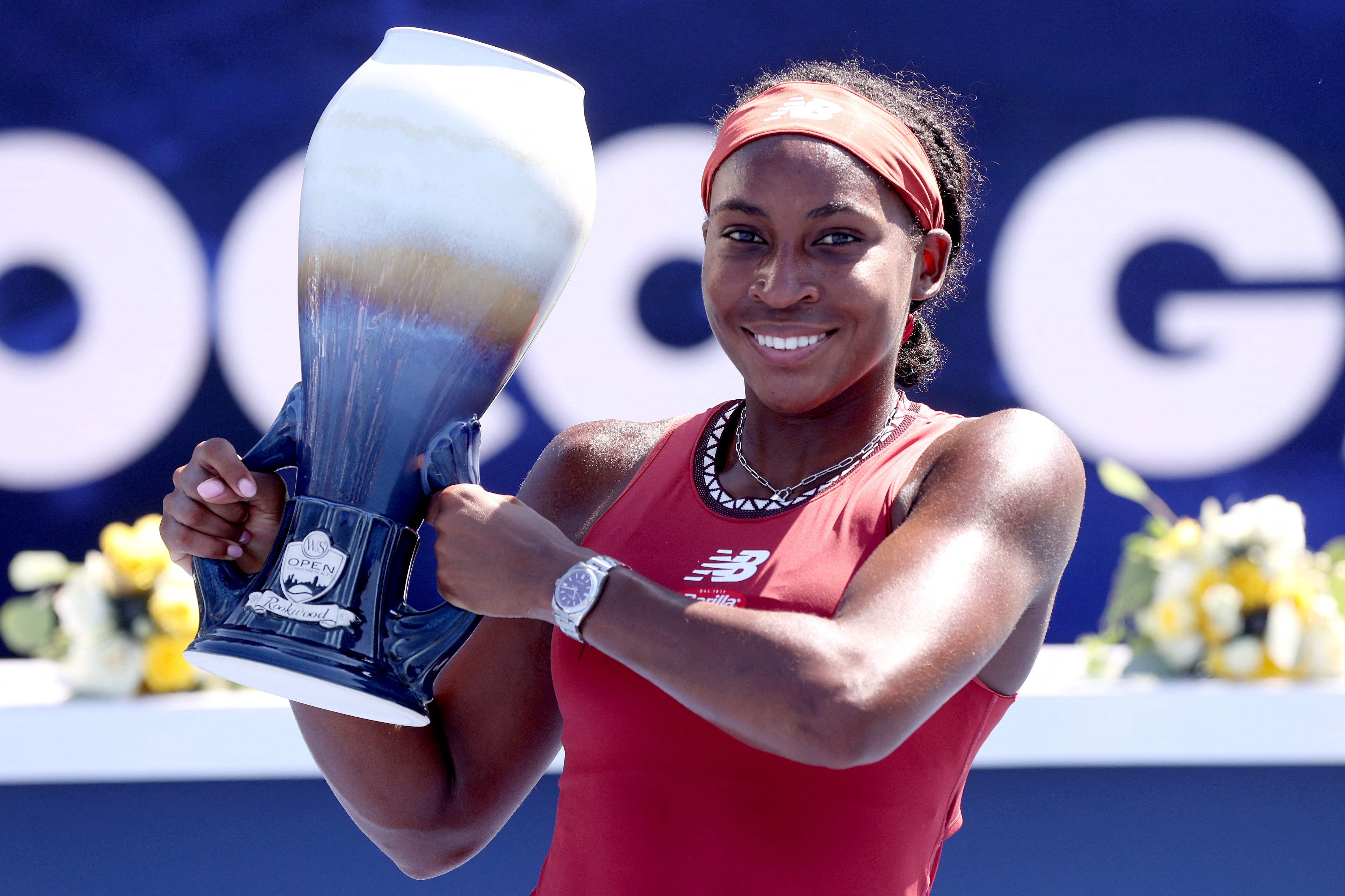 Coco Gauff memegang trofi kemenangan perdananya di WTA 1000 pada Minggu (20/8).