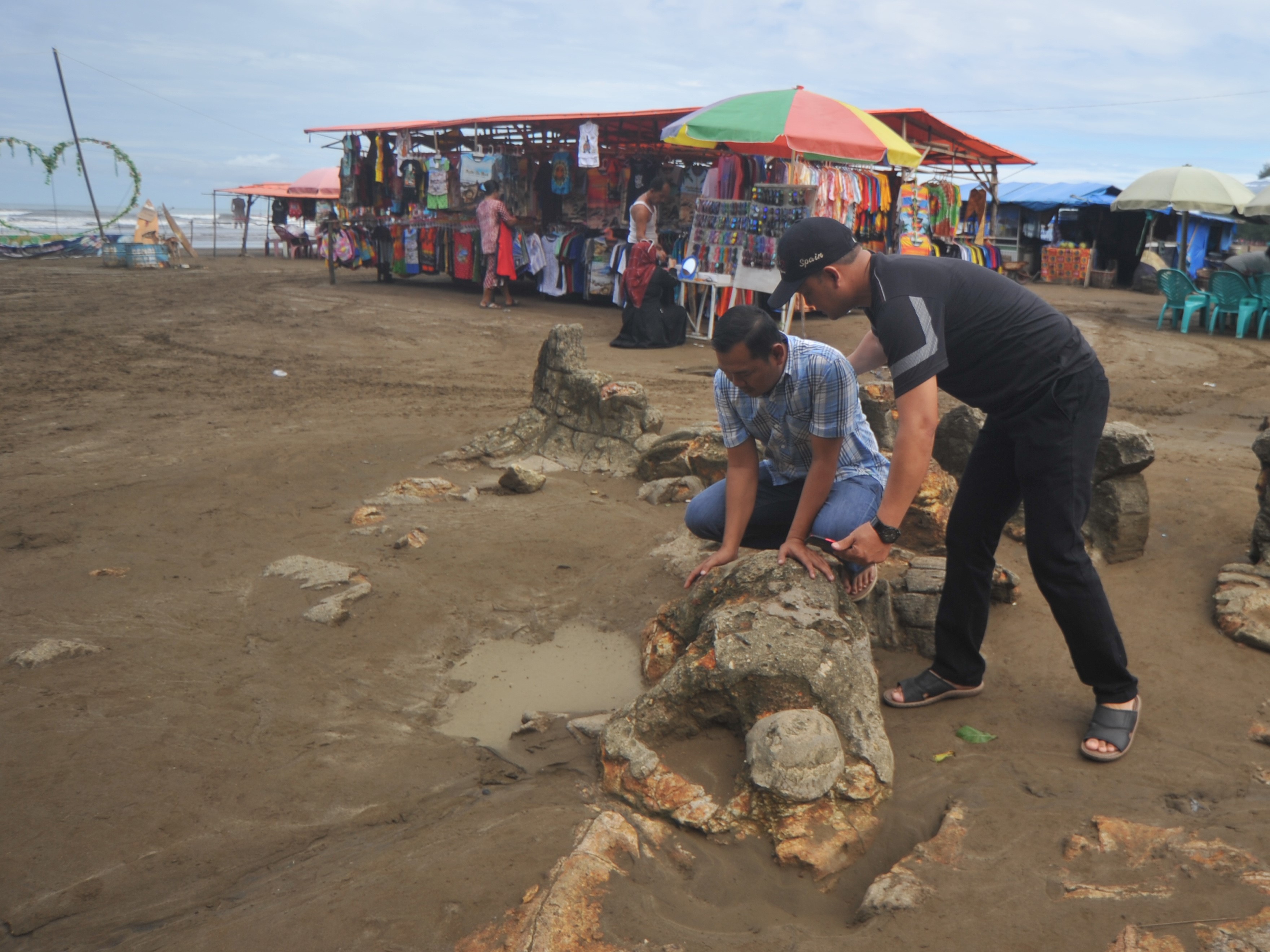 Pengunjung melihat Batu Malin Kundang di Pantai Air Manis, Padang, Sumatra Barat, Rabu (24/7/2019).