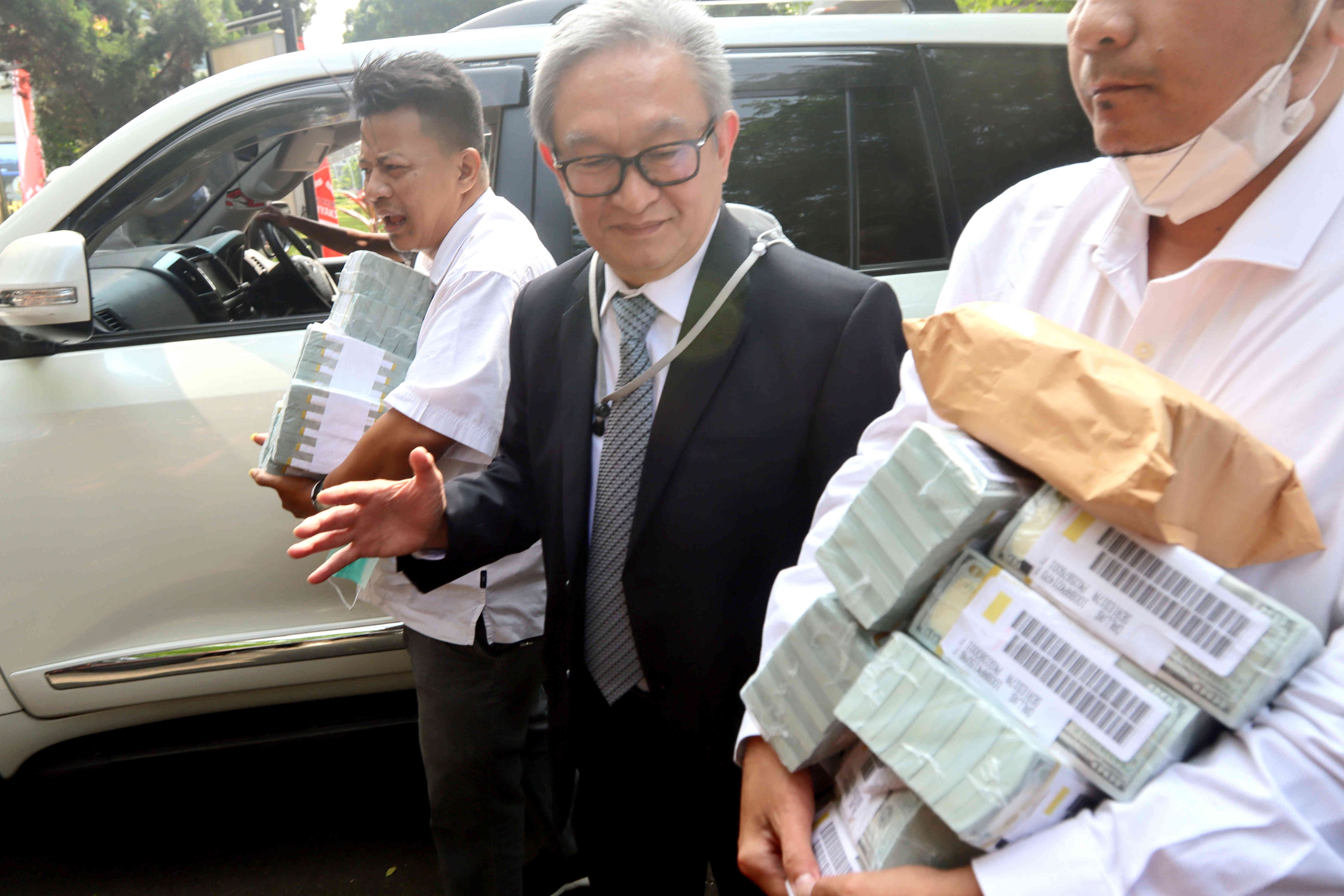 Maqdir Ismail (jas hitam) pengacara dari Irwan Hermawan dalam kasus korupsi BTS Bakti Kominfo, membawa uang sebesar Rp 27 miliar ke Kejagung