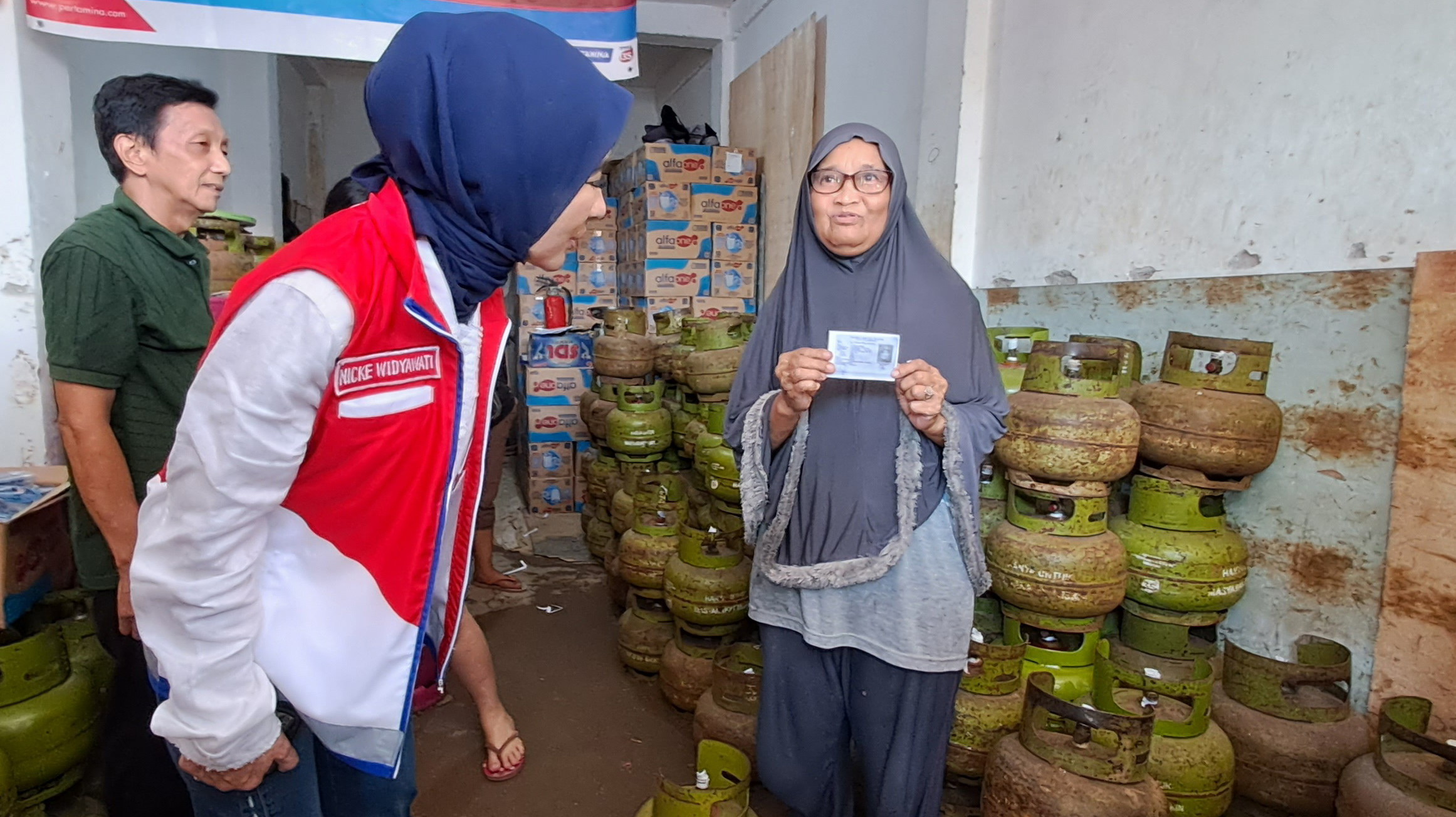  Direktur Utama PT Pertamina Nicke Widyawati (kedua dari kiri) memeriksa KTP warga yang akan membeli LPG 3 Kg di Palembang, Senin (31/7).