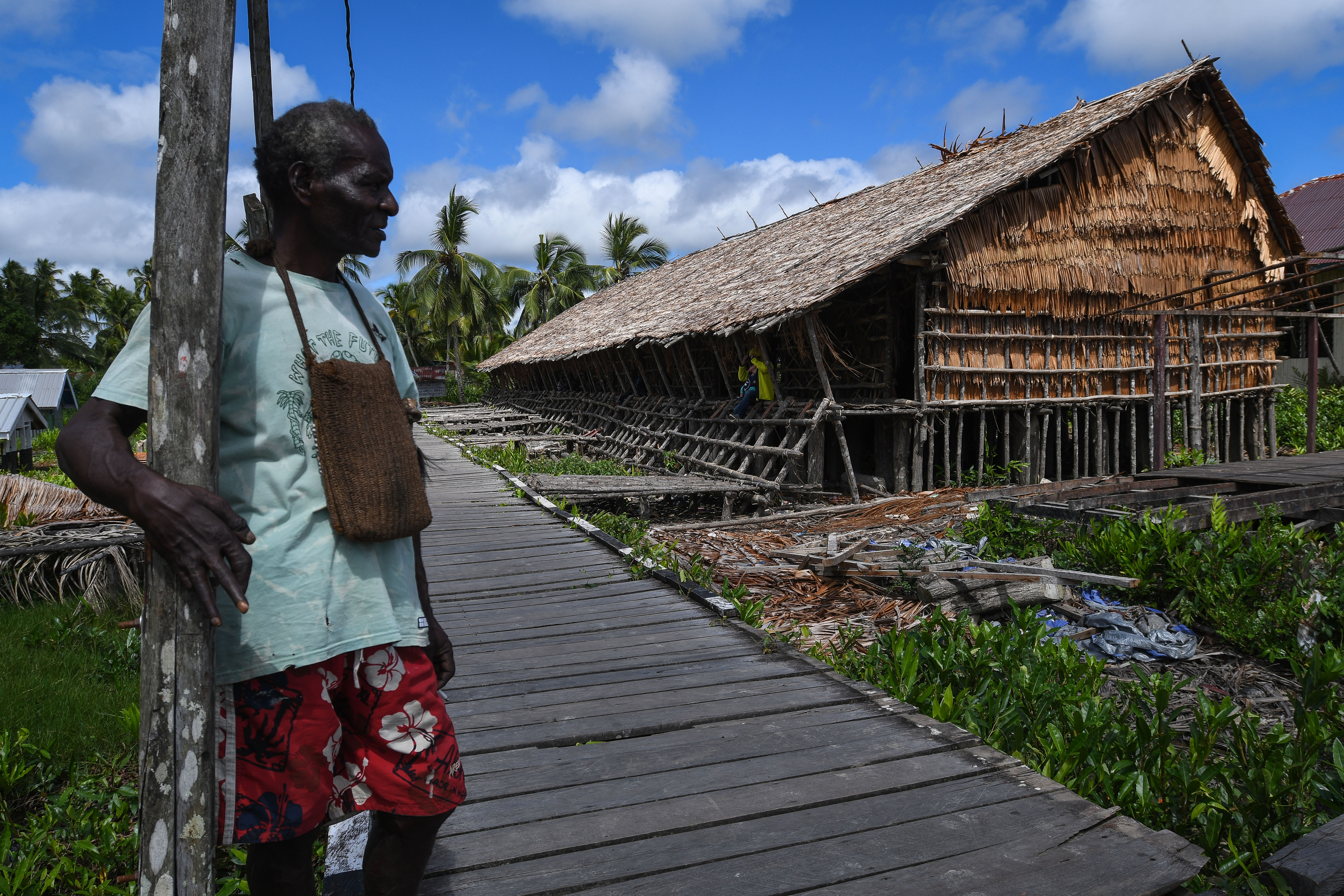 Warga berdiri di depan rumah adat Jew di Kampung Ewer, Distrik Agats, Kabupaten Asmat, Papua Selatan