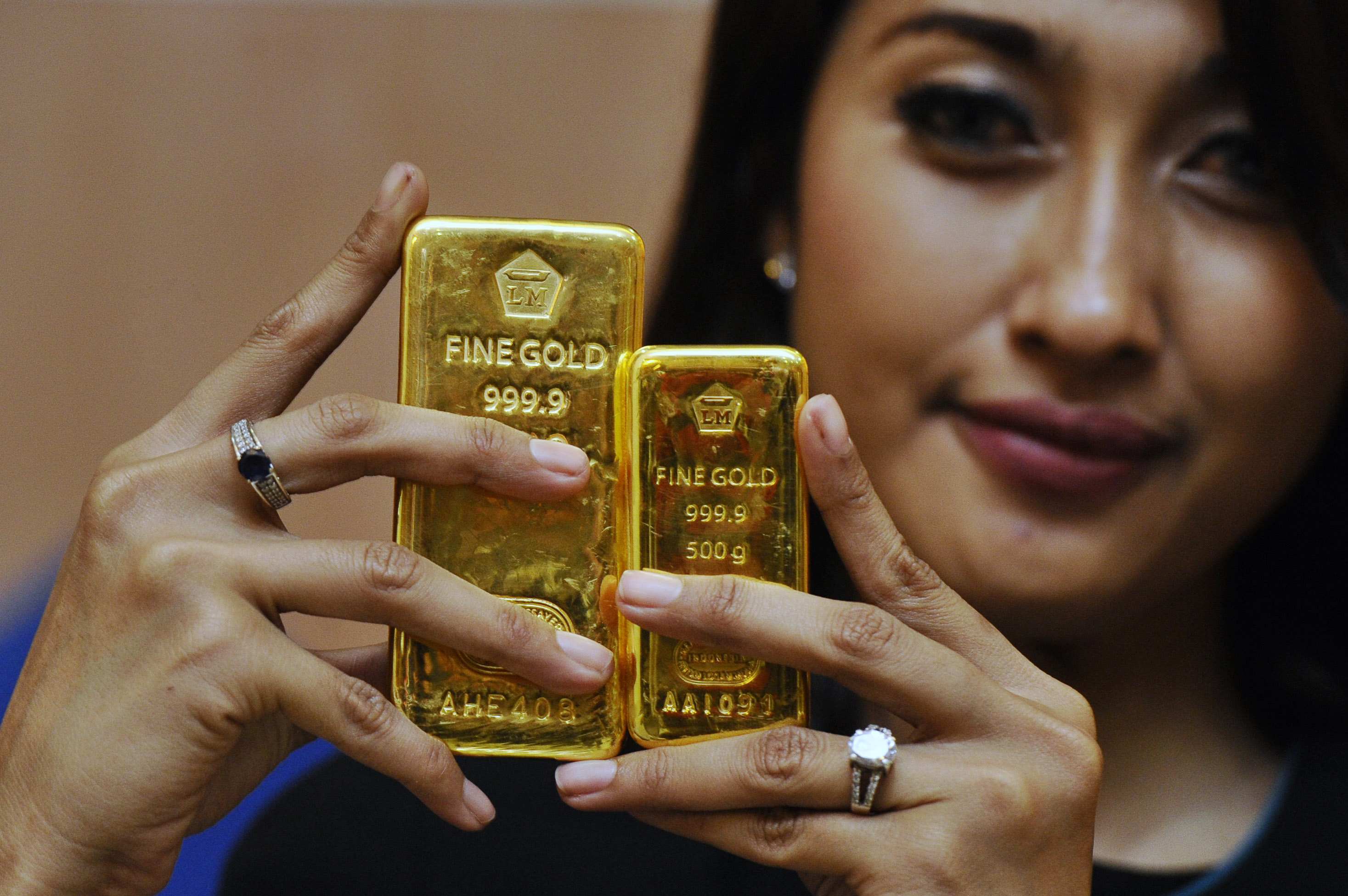 Seorang petugas memperlihatkan emas batangan produksi PT Antam di Jakarta, Senin (19/1/2015).