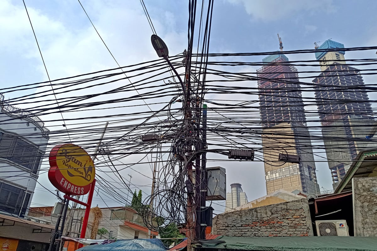 Kabel-kabel udara yang berseliweran dan semrawut di permukiman penduduk di kawasan Kebon Kacang, Jakarta.