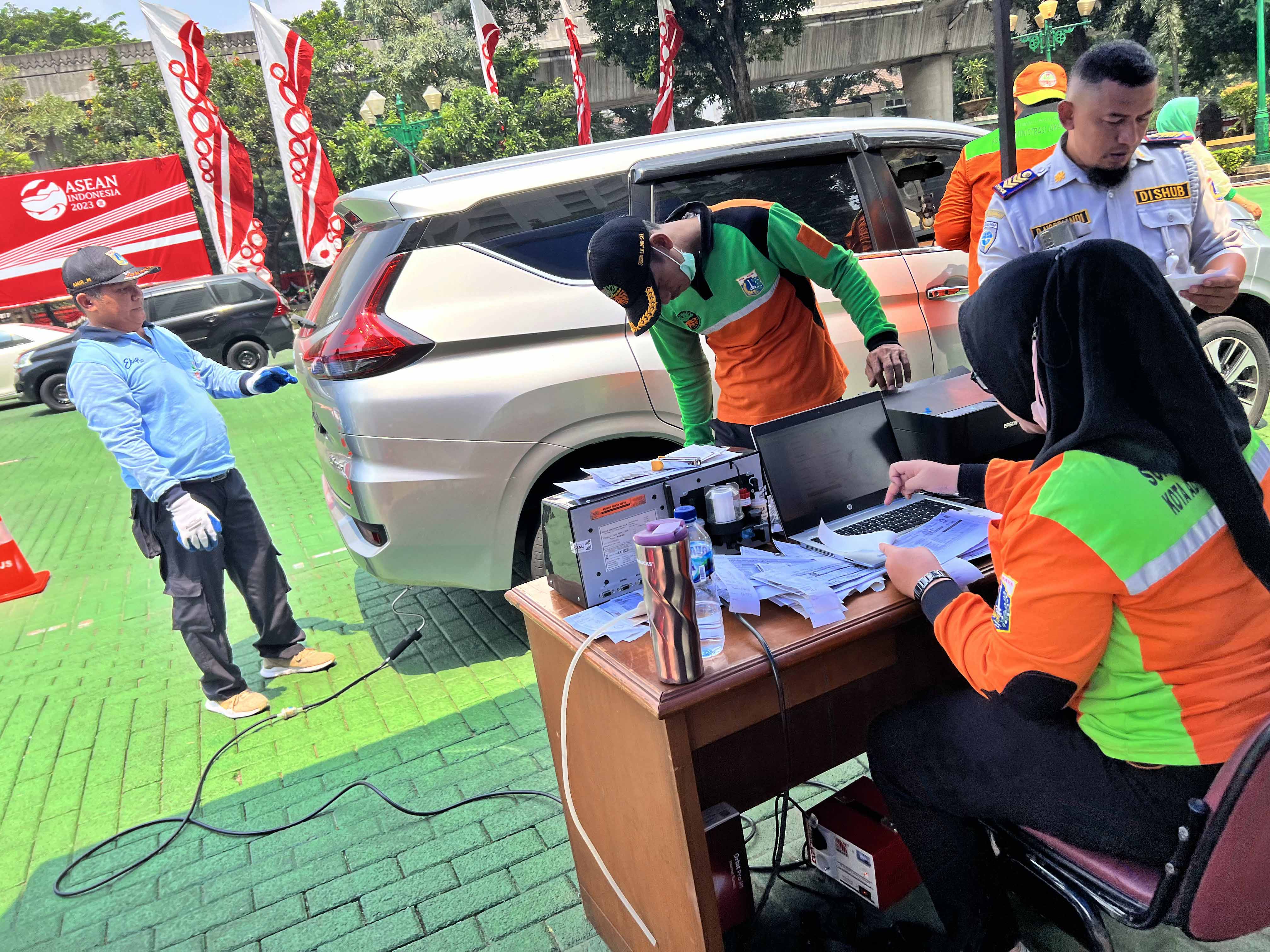 Petugas mengukur emisi gas buang kendaraan roda empat dan rosa dua di halaman kantor Wali Kota Jakarta Selatan, Rabu (30/8).