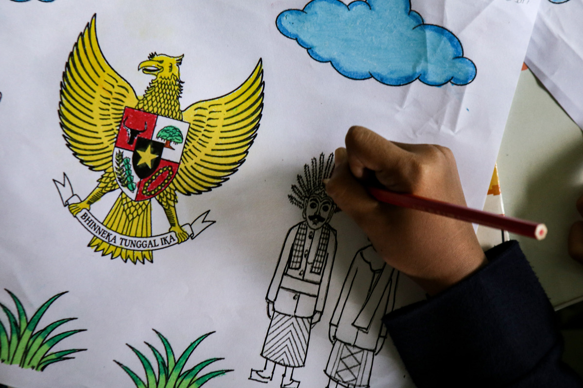 Anak usia sekolah saat mengikuti lomba mewarnai lambang negara Garuda Pancasila.