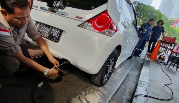 Petugas melakukan pengujian emisi pada kendaraan bermorot di Parkiran Gedung DPRD DKI Jakarta