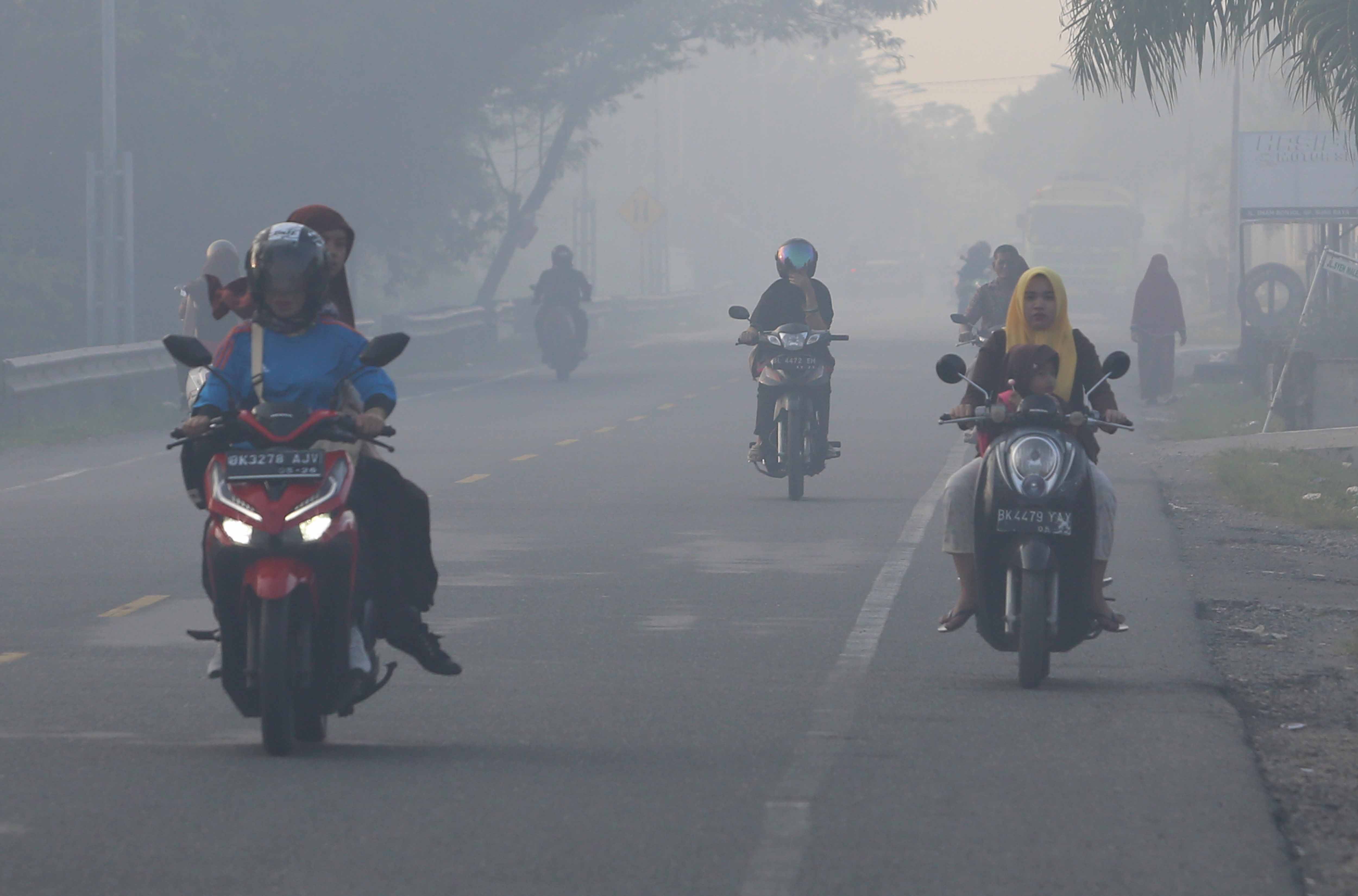  Sejumlah pengendara melintasi jalan yang berselimut kabut asap kebakaran hutan dan lahan di jalan lintas nasional Medan-Banda Aceh.