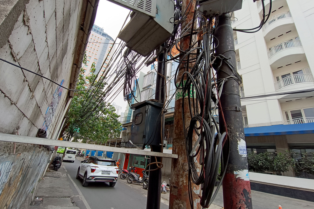 Kabel-kabel udara yang berseliweran dan semrawut di permukiman penduduk di kawasan Kebon Kacang, Jakarta.