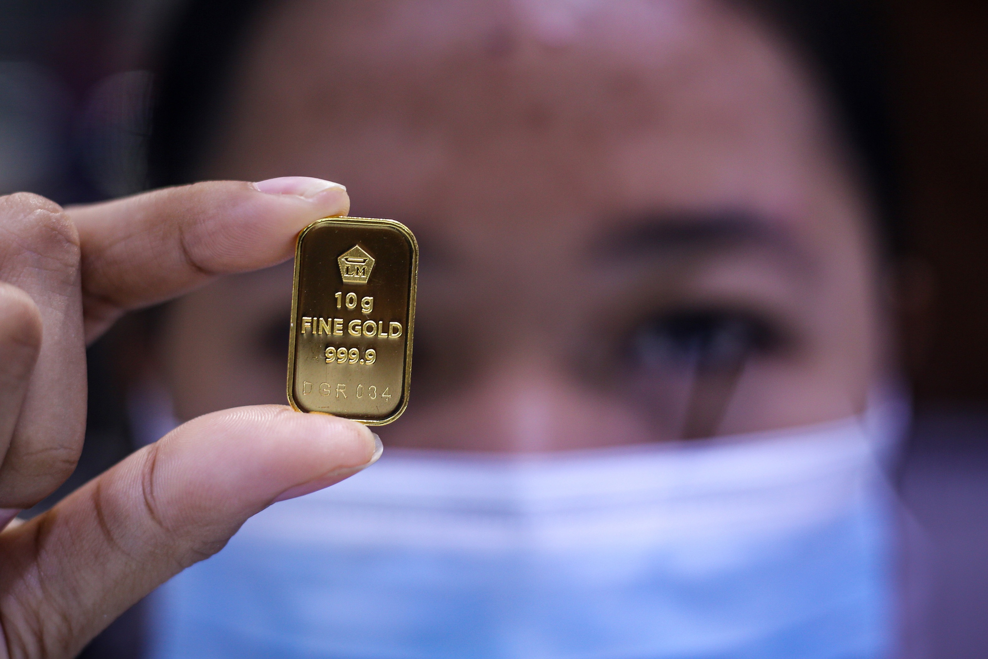 Seorang pegawai menunjukkan kepingan emas di toko perhiasan,Kota Tangerang, Banten, Jumat (25/9/2020).