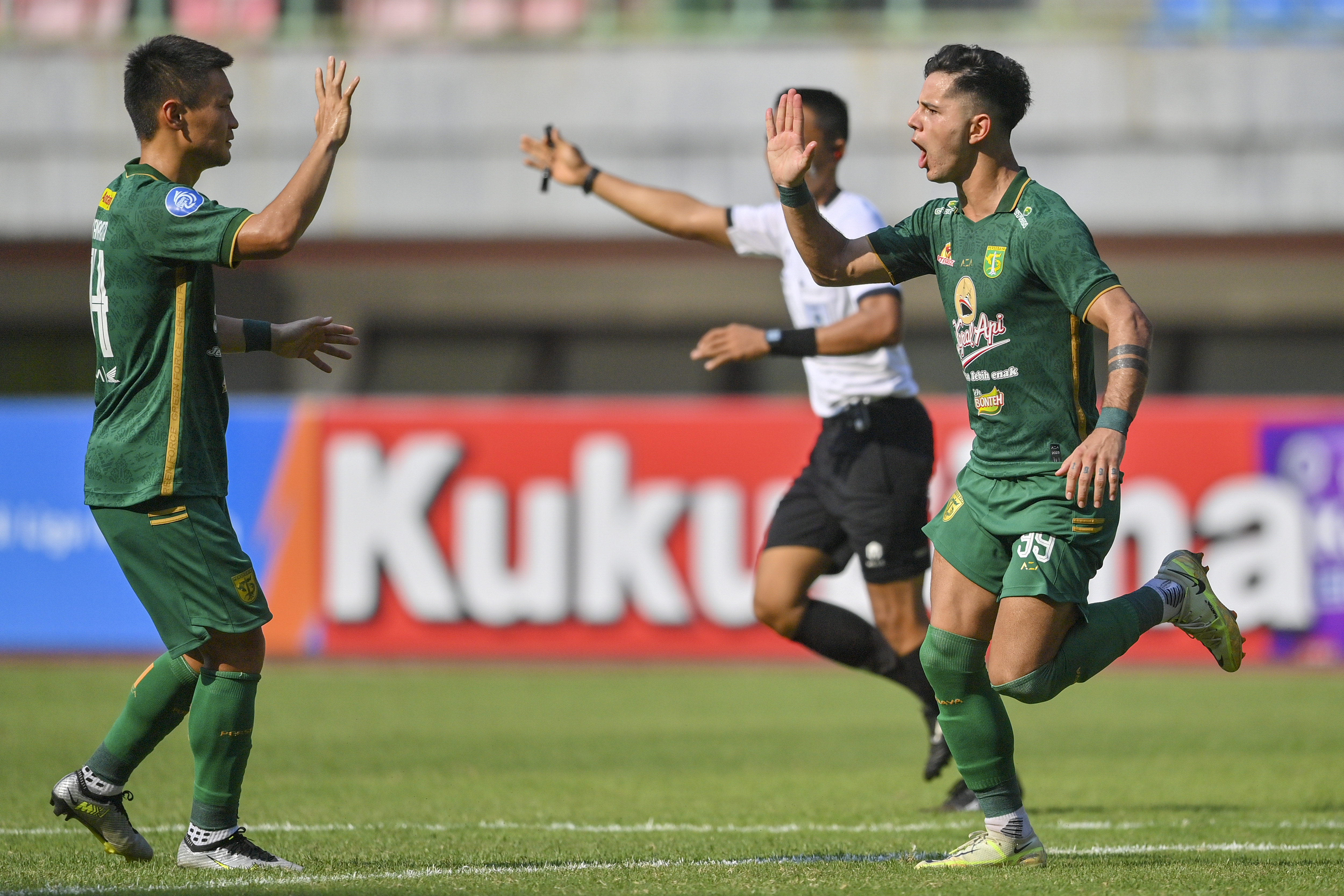 Pesepak bola Persebaya Surabaya Bruno Moreira (kanan) berselebrasi dengan Sho Yamamoto (kiri) usai mencetak gol ke gawang Bhayangkara FC