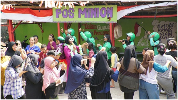 Warga bersama Mitra Pengemudi Grab bergoyang bersama setelah gotong royong memperbaiki fasilitas umum di Gandul, Ciputat. 