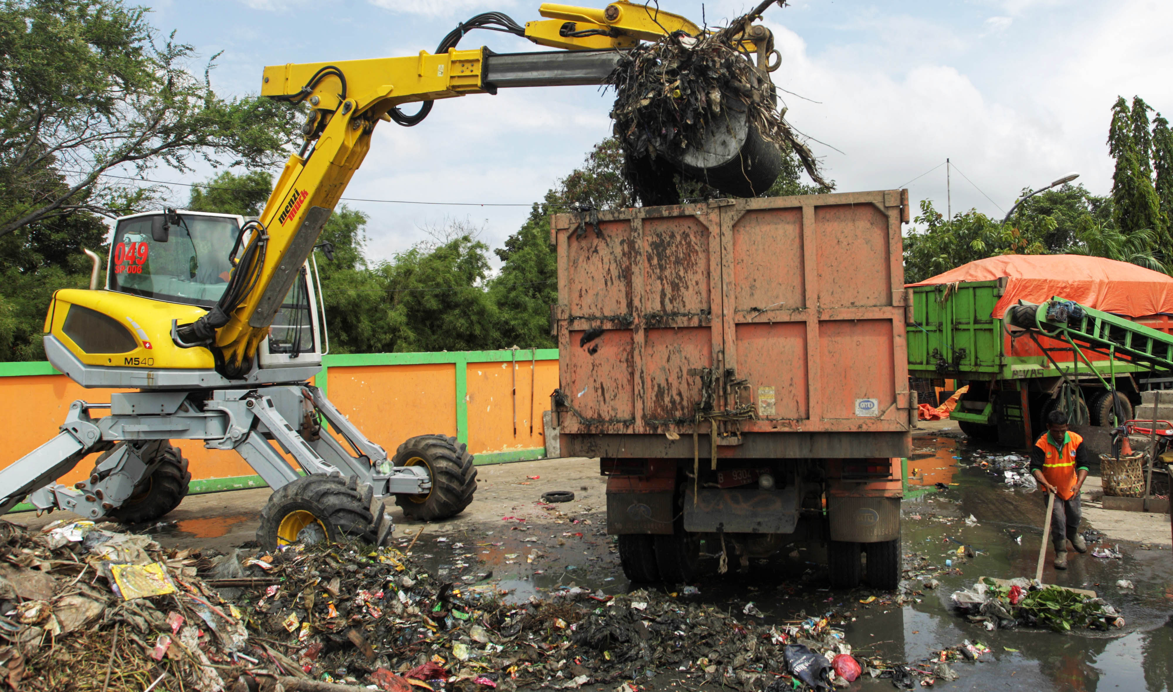 Pekerja menggunakan alat berat memindahkan sampah di area proyek Fasilitas Pengolahan Sampah Terpadu atau ITF Sunter.