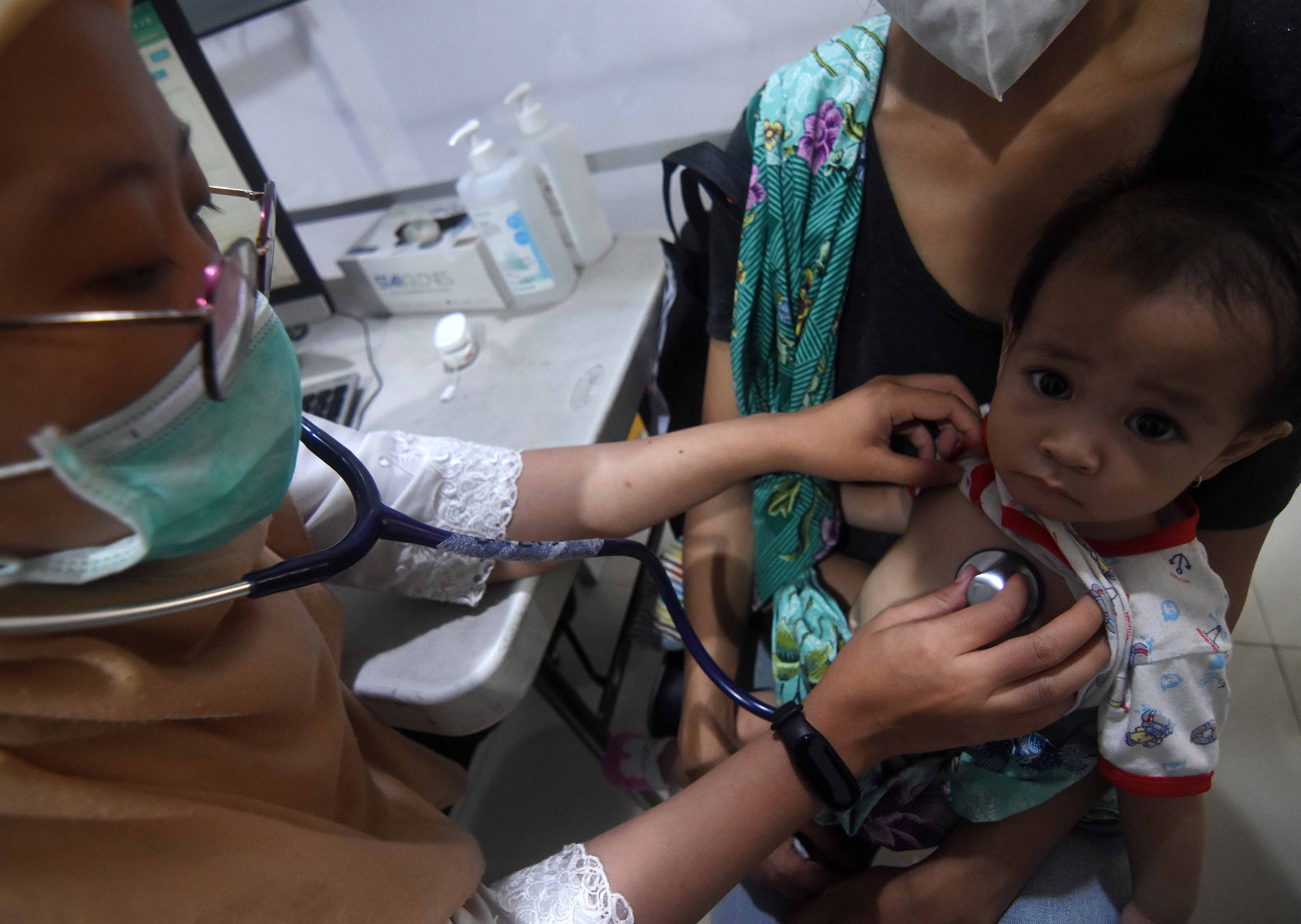  Dokter melakukan pemeriksaan kesehatan terhadap pasien bergejala Infeksi Saluran Pernapasan Akut (ISPA).