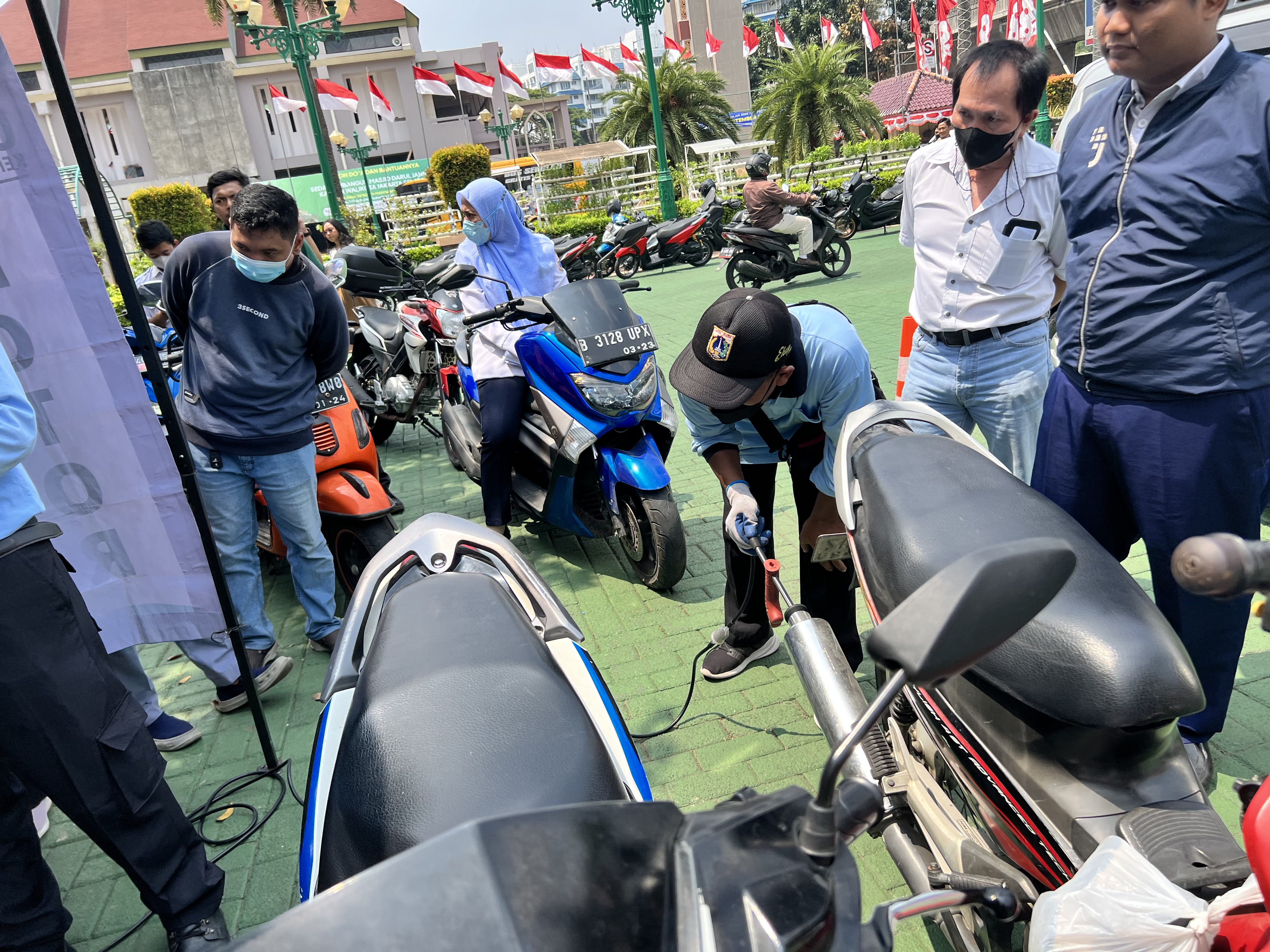 Petugas mengukur emisi gas buang kendaraan roda empat dan rosa dua di halaman kantor Wali Kota Jakarta Selatan, Rabu (30/8). 