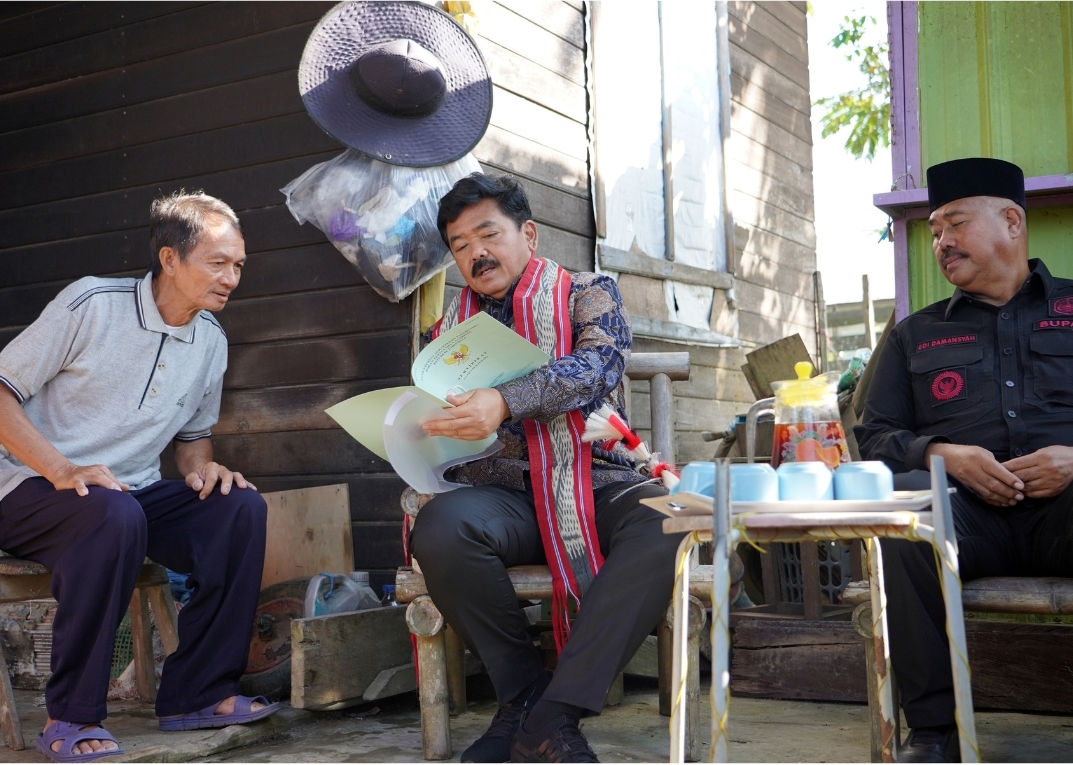 Menteri ATR/BPN Hadi Tjahjanto menyerahkan sertifikat tanah milik masyarakat secara door to door di Kelurahan Jabah, Kalimantan Timur. 