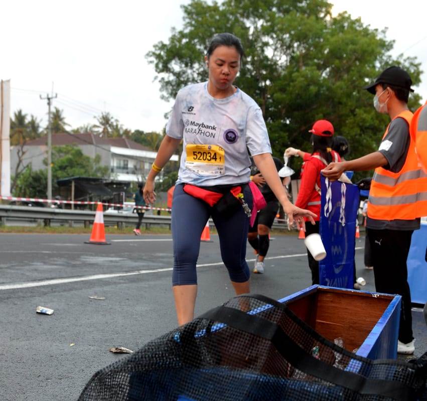 Pelari membuat sampah pada tempat yang disediakan komunitas Malu Dong sebagai bagai kampanye peduli lingkungan dari Aqua dan Maybank. 