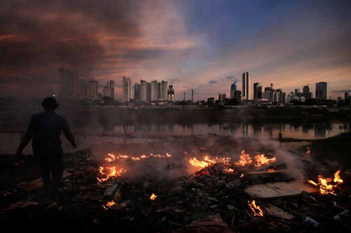 Warga membakar sampah di bantaran Banjir Kanal Barat, kawasan Pertamburan Jakarta, beberapa waktu lalu.