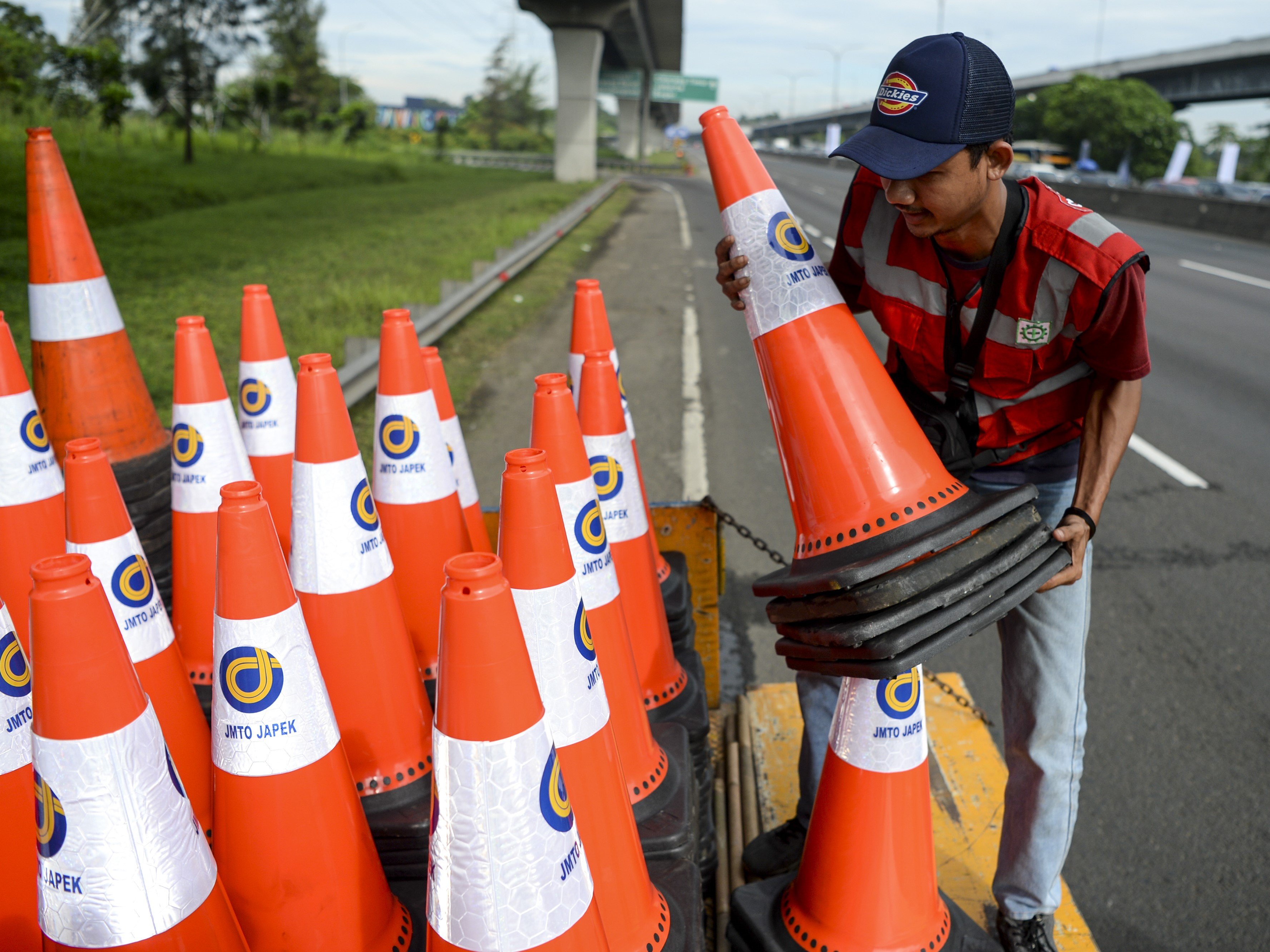 Pekerja merapikan rambu kerucut pada ruas jalan tol Jakarta-Cikampek kilometer 47 di Karawang, Jawa Barat.