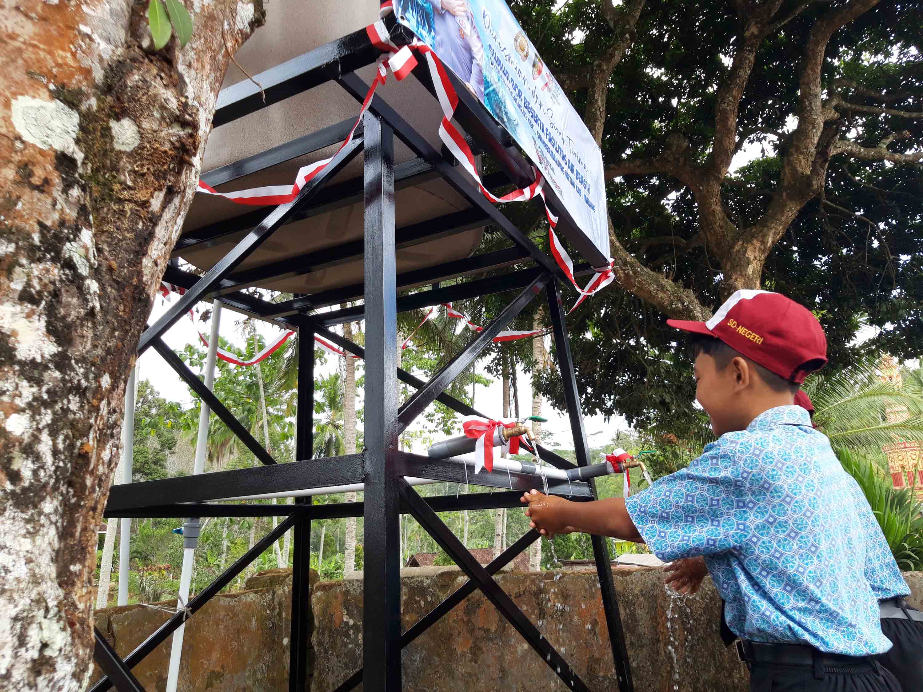 Siswa SD Negeri 01 Tegalrejo, Kecamatan Sumbermanjing Wetan, Kabupaten Malang, Jawa Timur, memanfaatkan air bersih dari sumur bor 