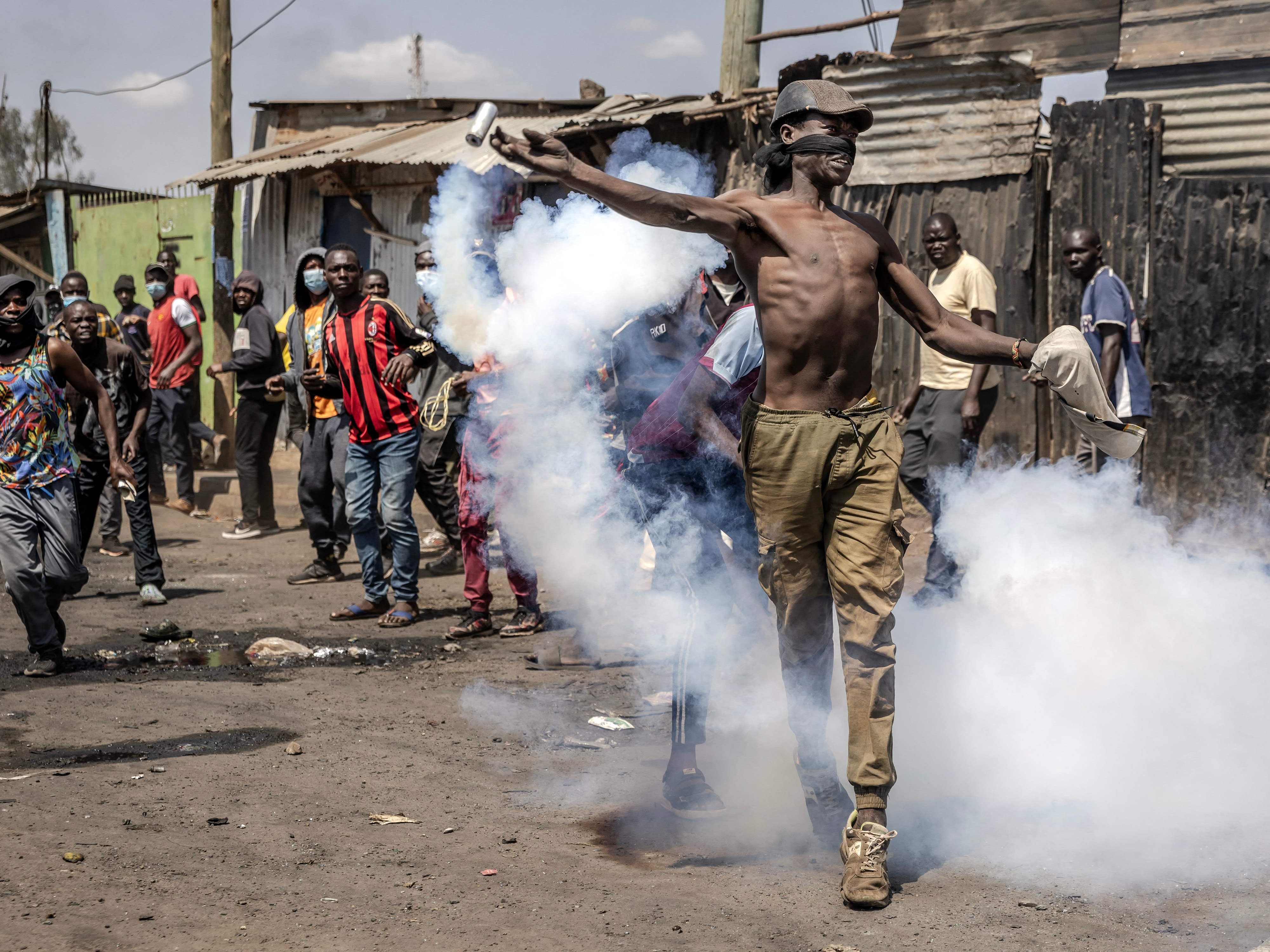 Seorang pendukung oposisi melempar tabung gas air mata yang ditembakkan oleh polisi antihuru hara saat bentrok di Nairobi, Kenya. 