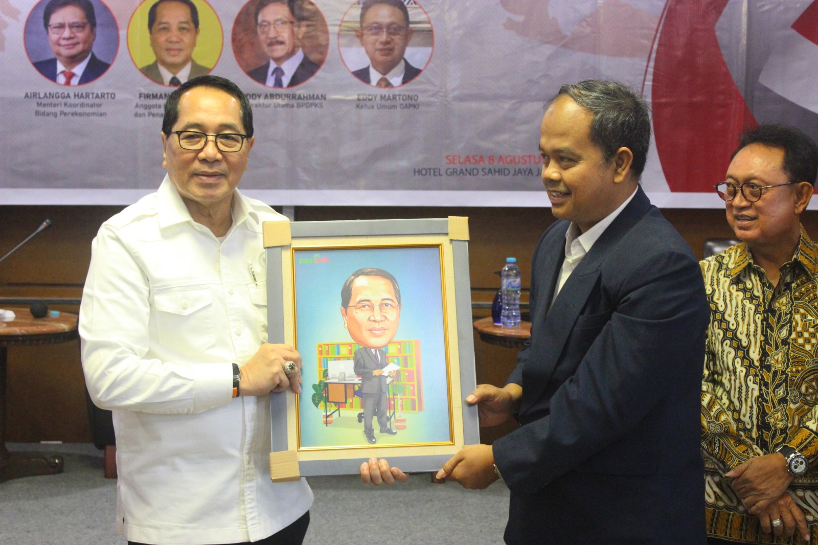 Anggota Komisi IV DPR Firman Soebagio (kiri) menerima lukisan karikatur seusai menjadi pembicara seminar di Hotel Sahid, Jakarta.  