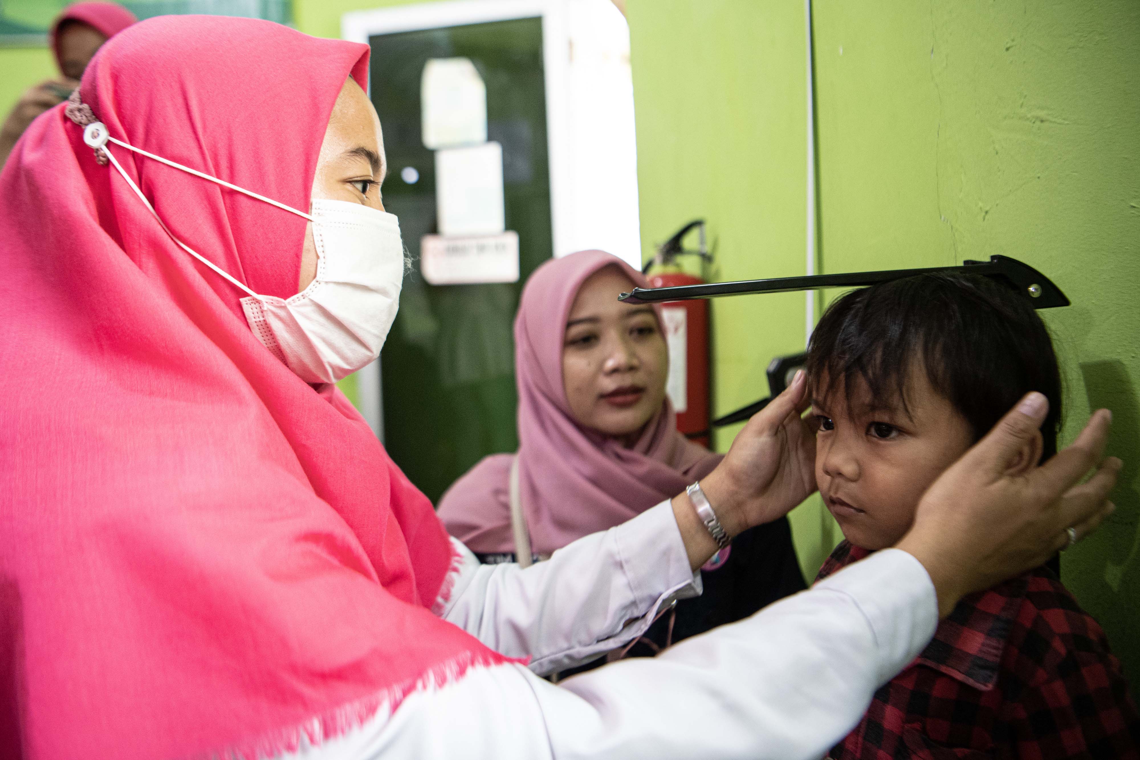 Petugas kesehatan mengukur tinggi badan balita saat pelaksanaan program Penanganan Anak Kurang Gizi atau Stunting.