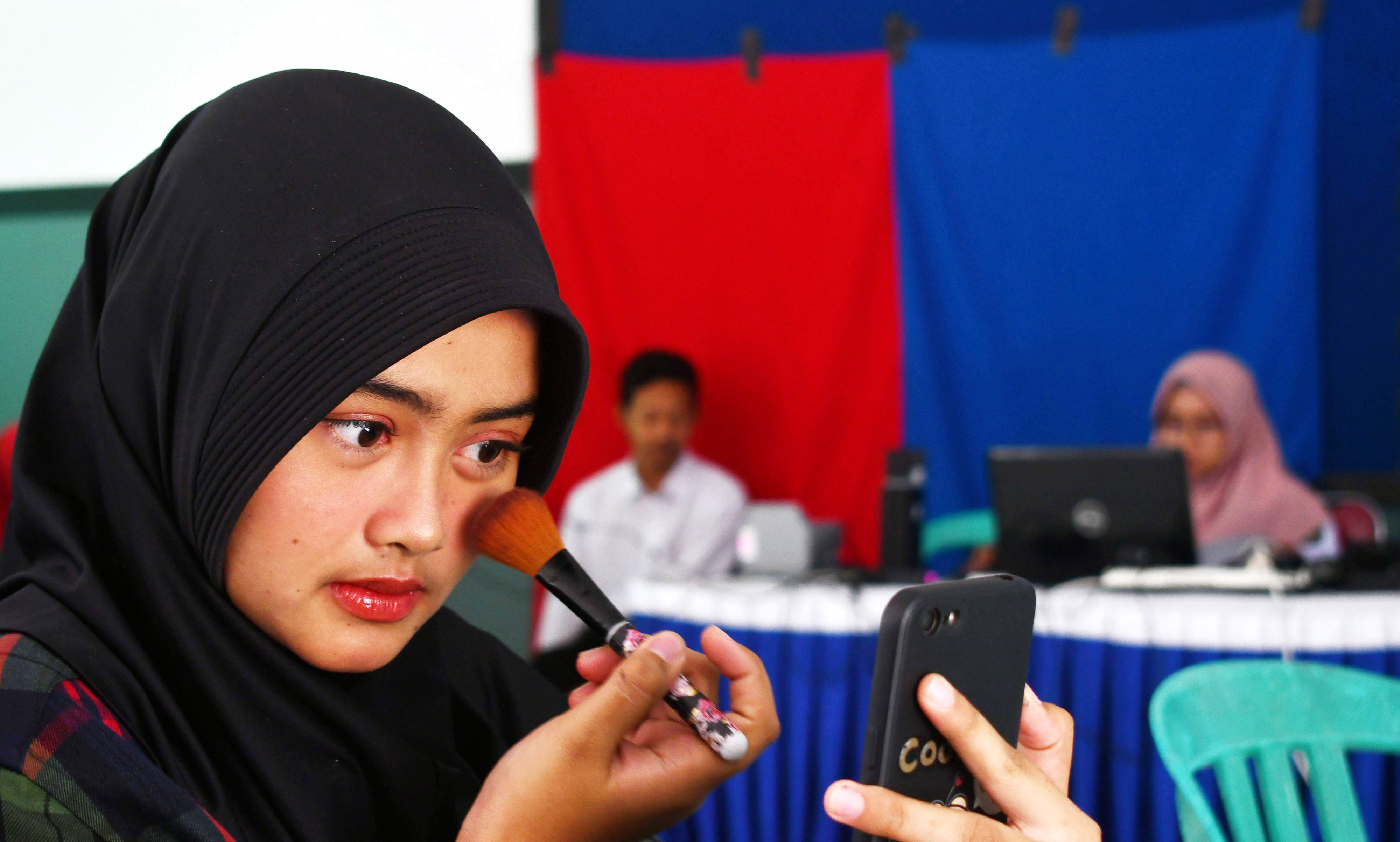 Ilustrasi--Pelajar perempuan bersolek menjelang perekaman data KTP elektronik di SMKN 5 Kota Madiun, Jawa Timur.