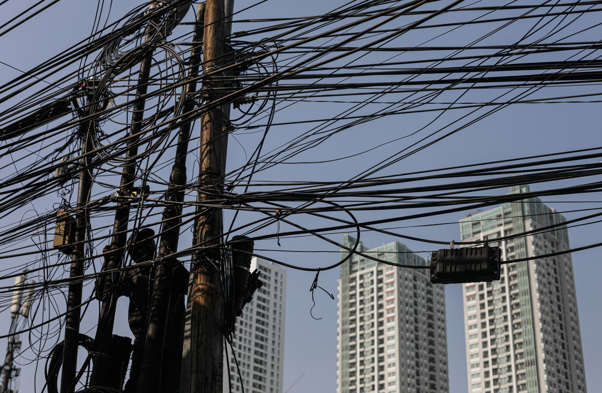 Petugas memasang kabel serat optik diantara tumpukan kabel yang semrawut di kawasan Tanah Abang, Jakarta.