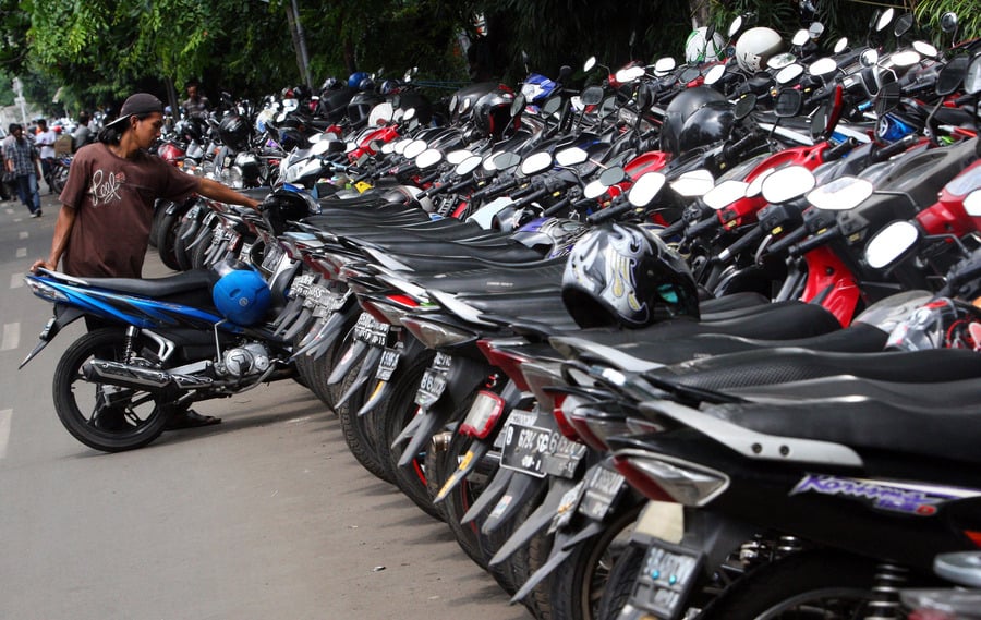 Petugas merapikan motor di area parkir pinggir jalan kawasan Kebon Kacang, Tanah Abang, Jakarta.