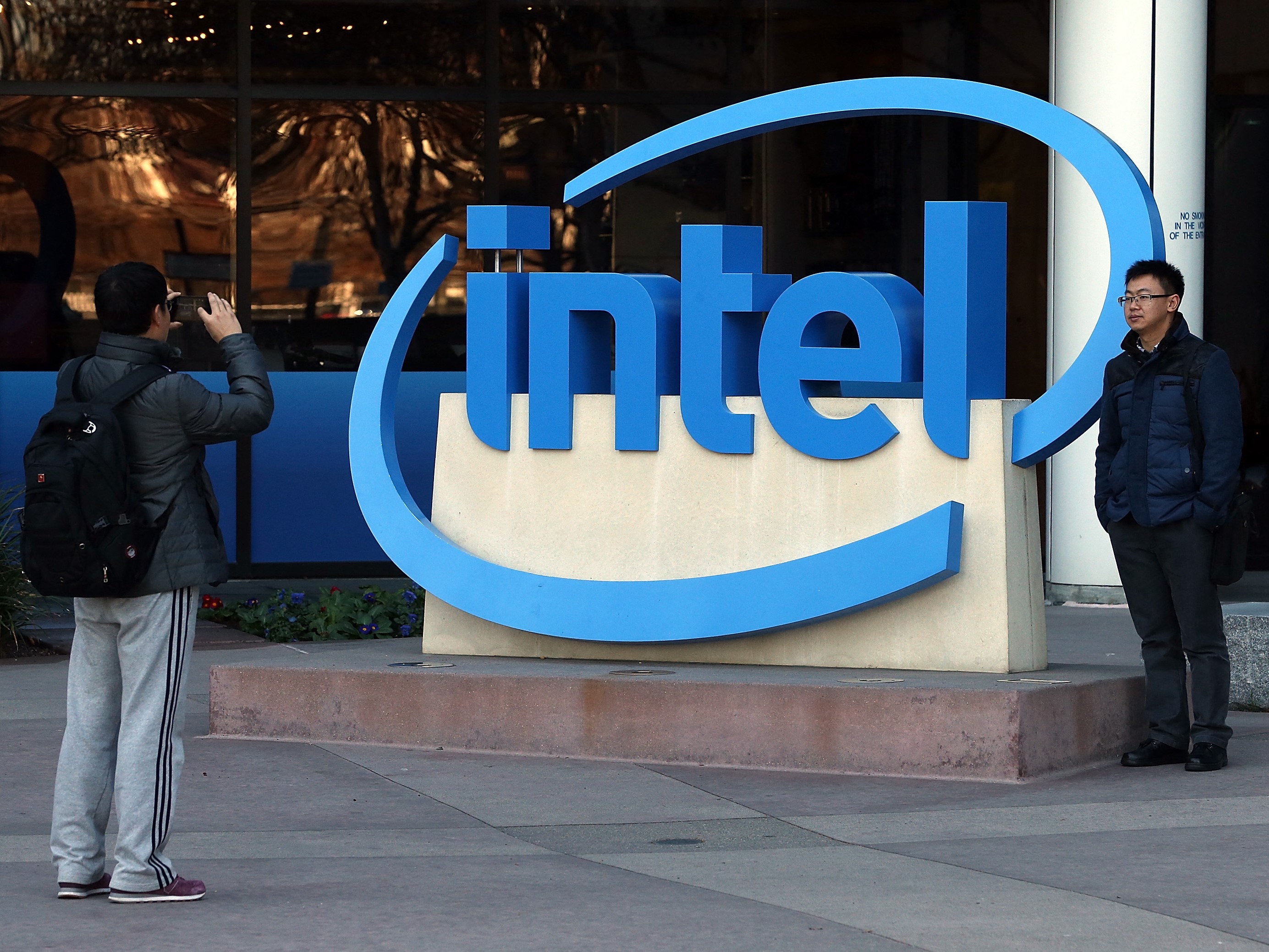Pengunjung mengambil gambar di samping logo Intel di luar kantor pusat Intel pada 16 Januari 2014 di Santa Clara, California.