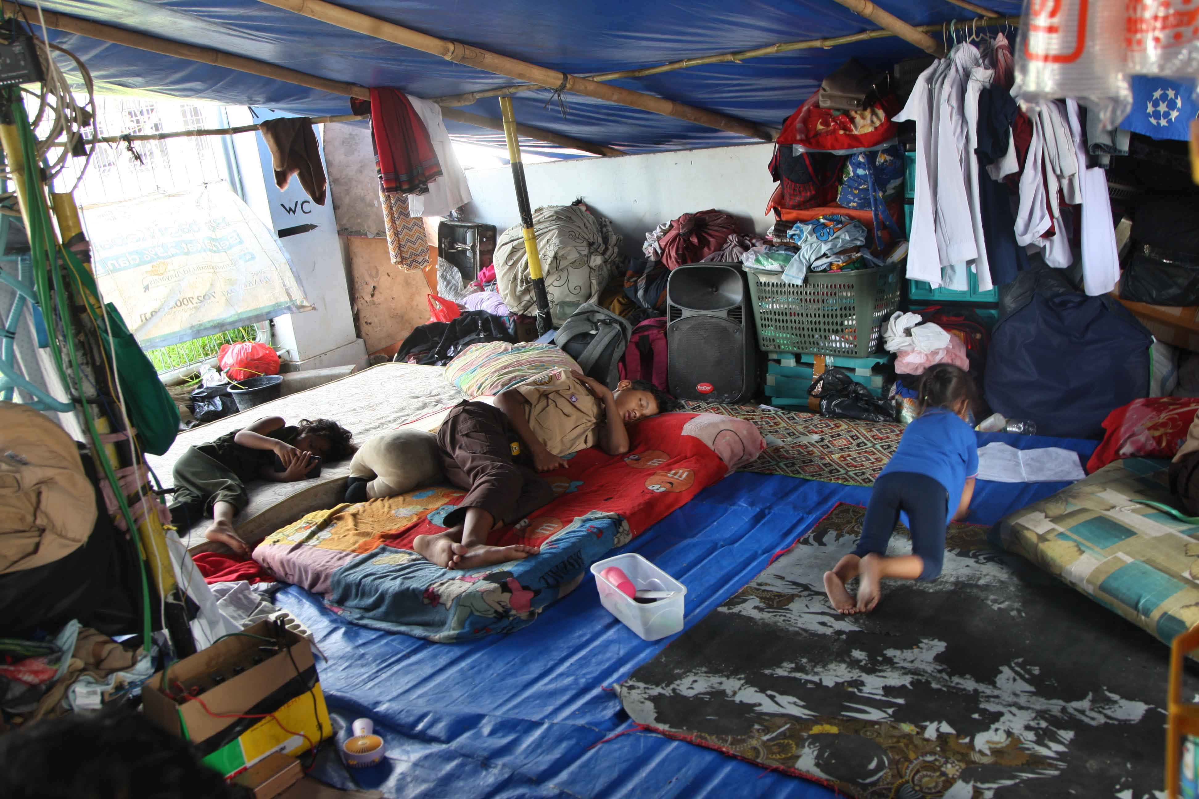 Warga Kampung Bayam mengungsi di pintu masuk Jakarta International Stadium (JIS) di Jakarta.