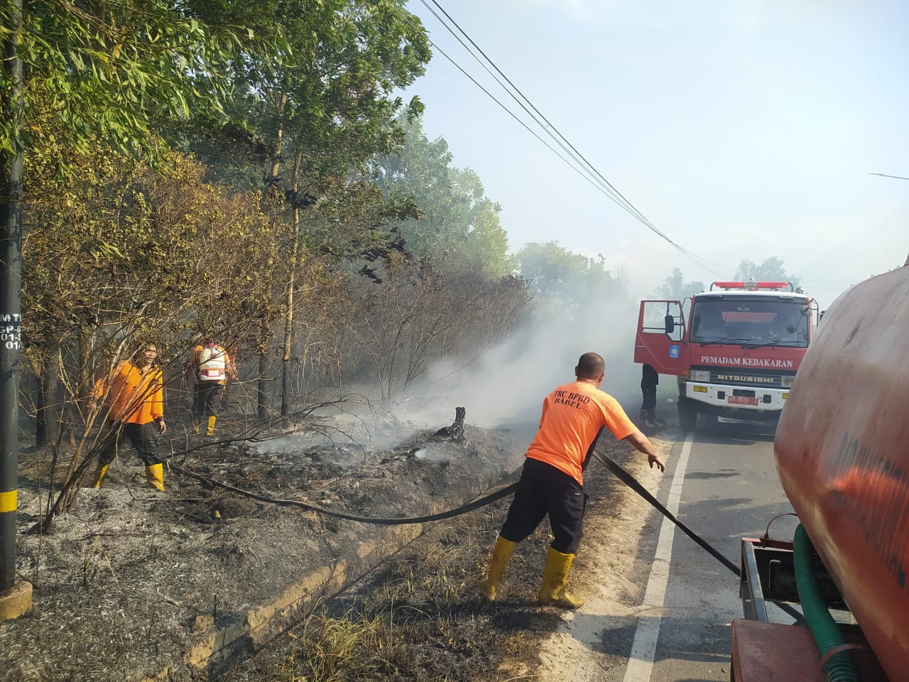 Petugas melakukan pemadaman di lahan yang terbakar di Bangka Belitung, Kamis (28/9).