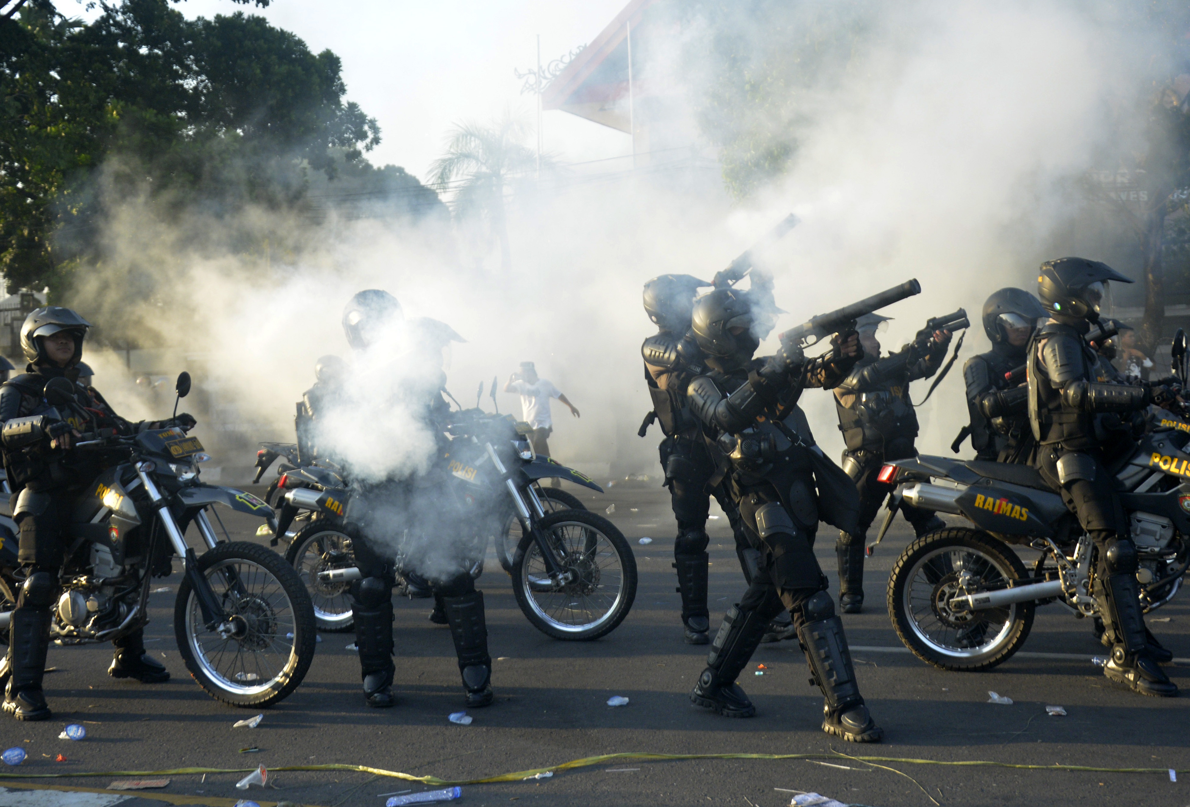 Ilustrasi--Anggota polisi menembakkan gas air mata ke arah pengunjuk rasa di Makassar, Sulawesi Selatan.