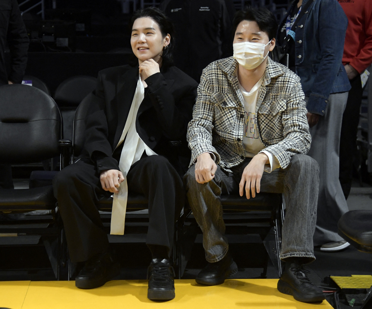 Suga BTS, saat menonton pertandingan basket di AS (kiri).