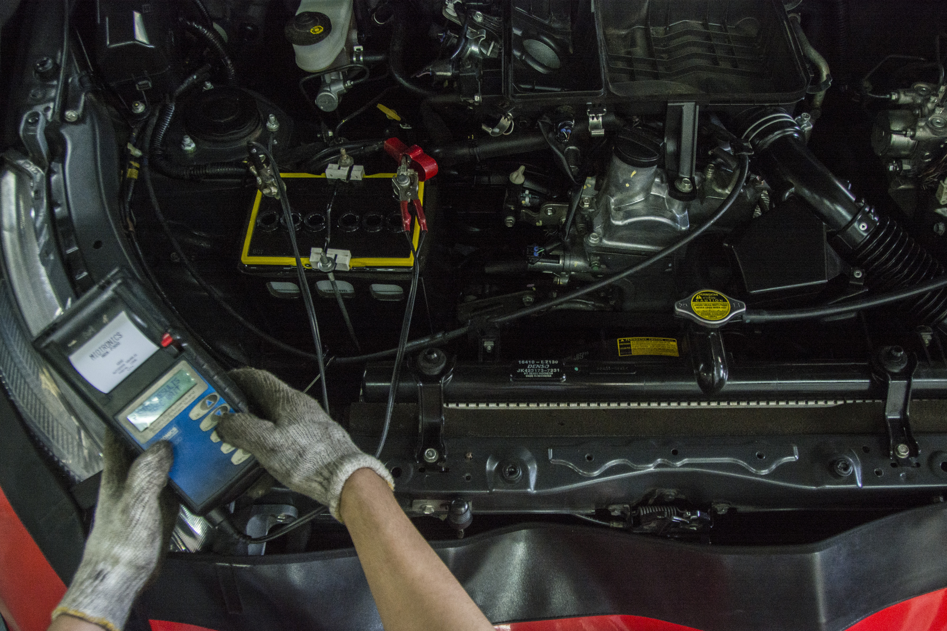 Ilustrasi pekerja mengecek kondisi mesin mobil