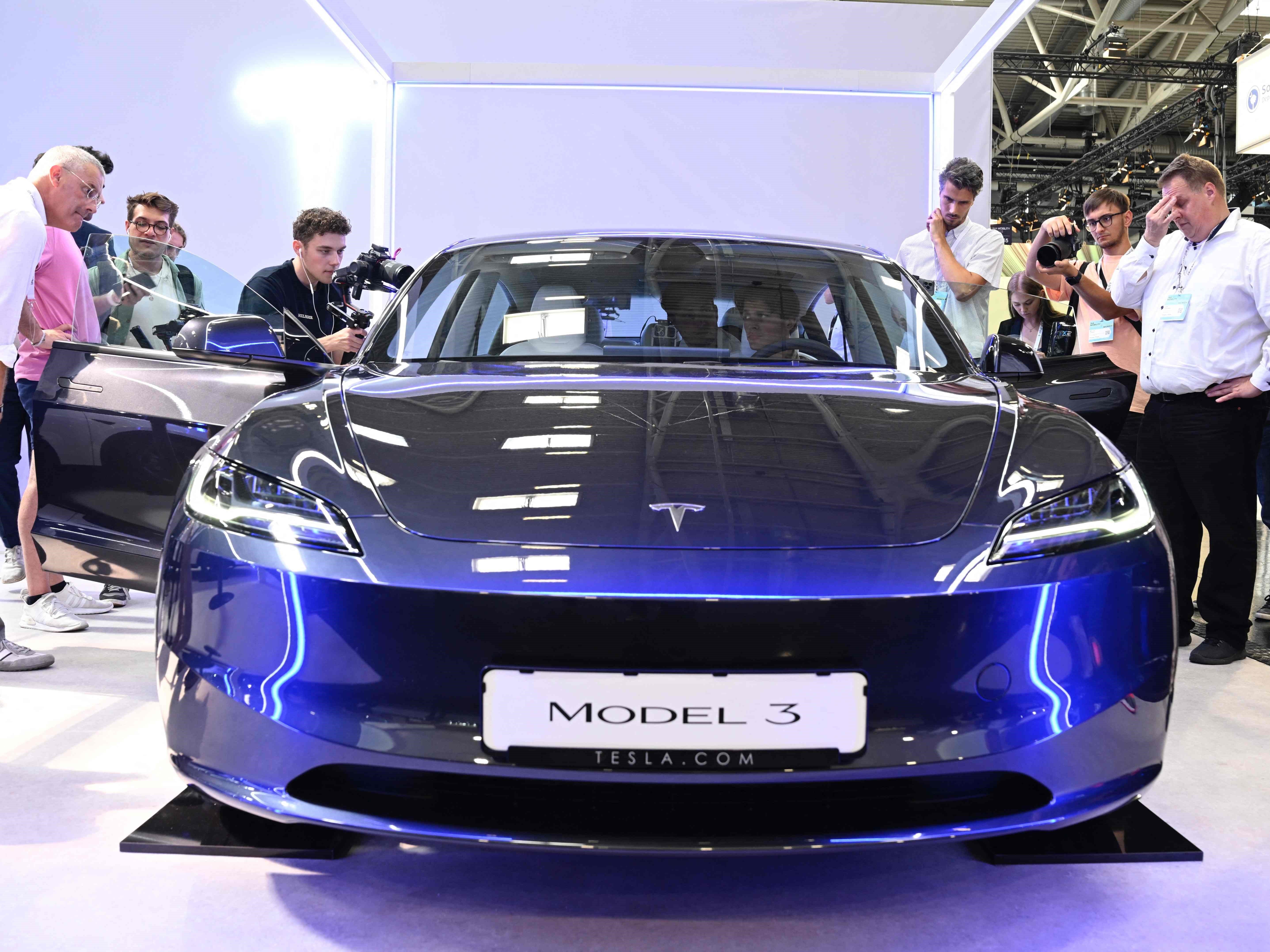 Pengunjung memeriksa mobil Tesla model 3 yang dipamerkan di International Motor Show (IAA) di Munich, Jerman selatan, pada 4 September 2023.