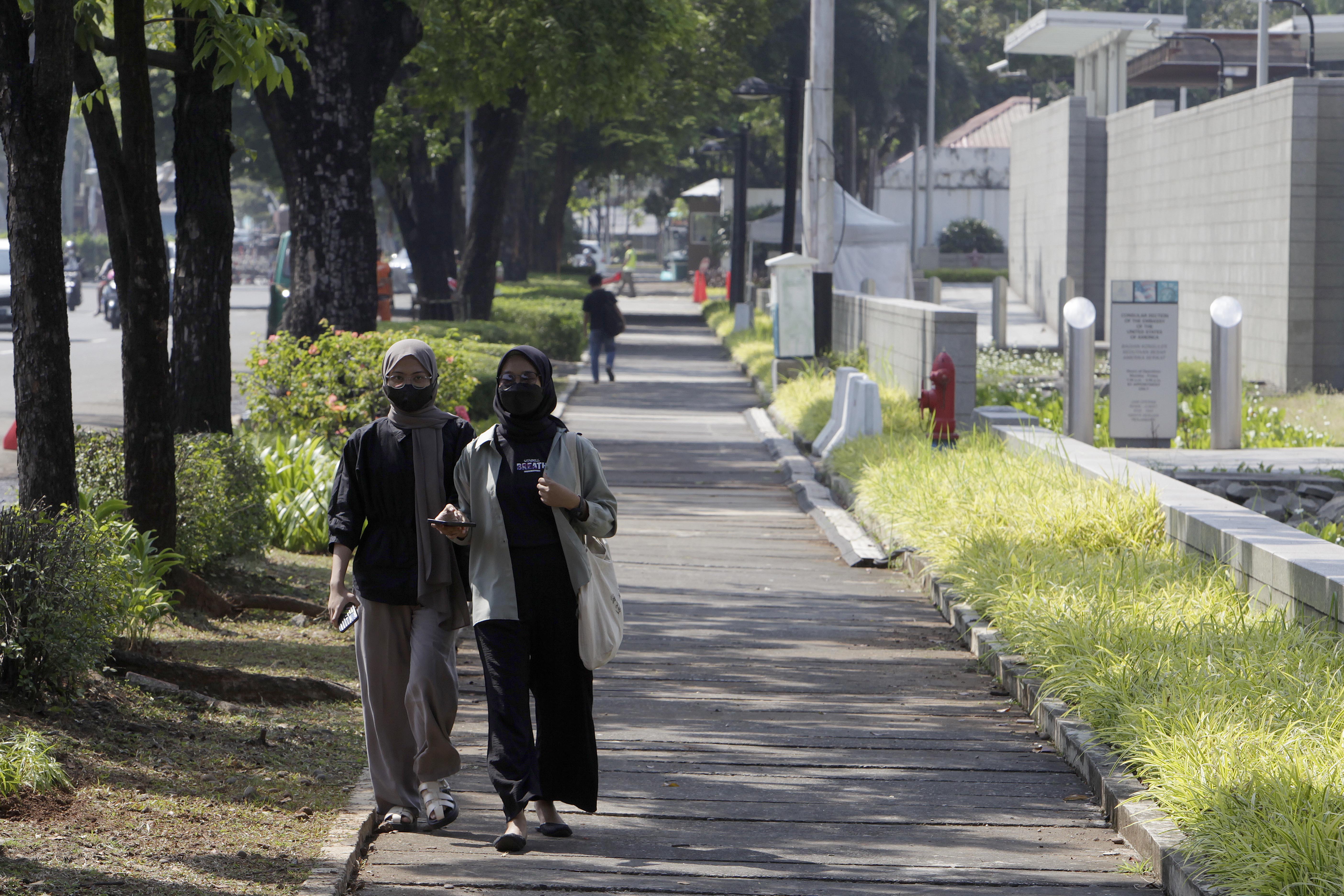 Warga melalintasi trotoar di depan Kedubes Amerika Serikat, Jakarta, Minggu (11/6). Warga Jakarta diimbau jalan kaki untuk kurangi polusi.