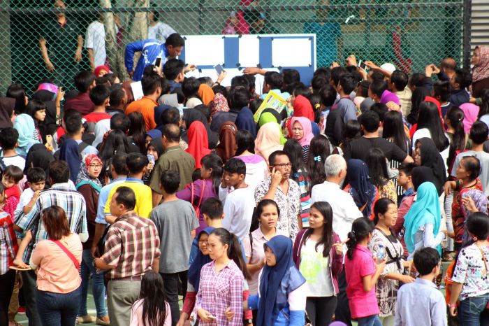 Ilustrasi: sejumlah orang tua murid mengecek daftar nama-nama siswa yang dinyatakan lulus di salah satu SMAN di Medan, Sumatera Utara.