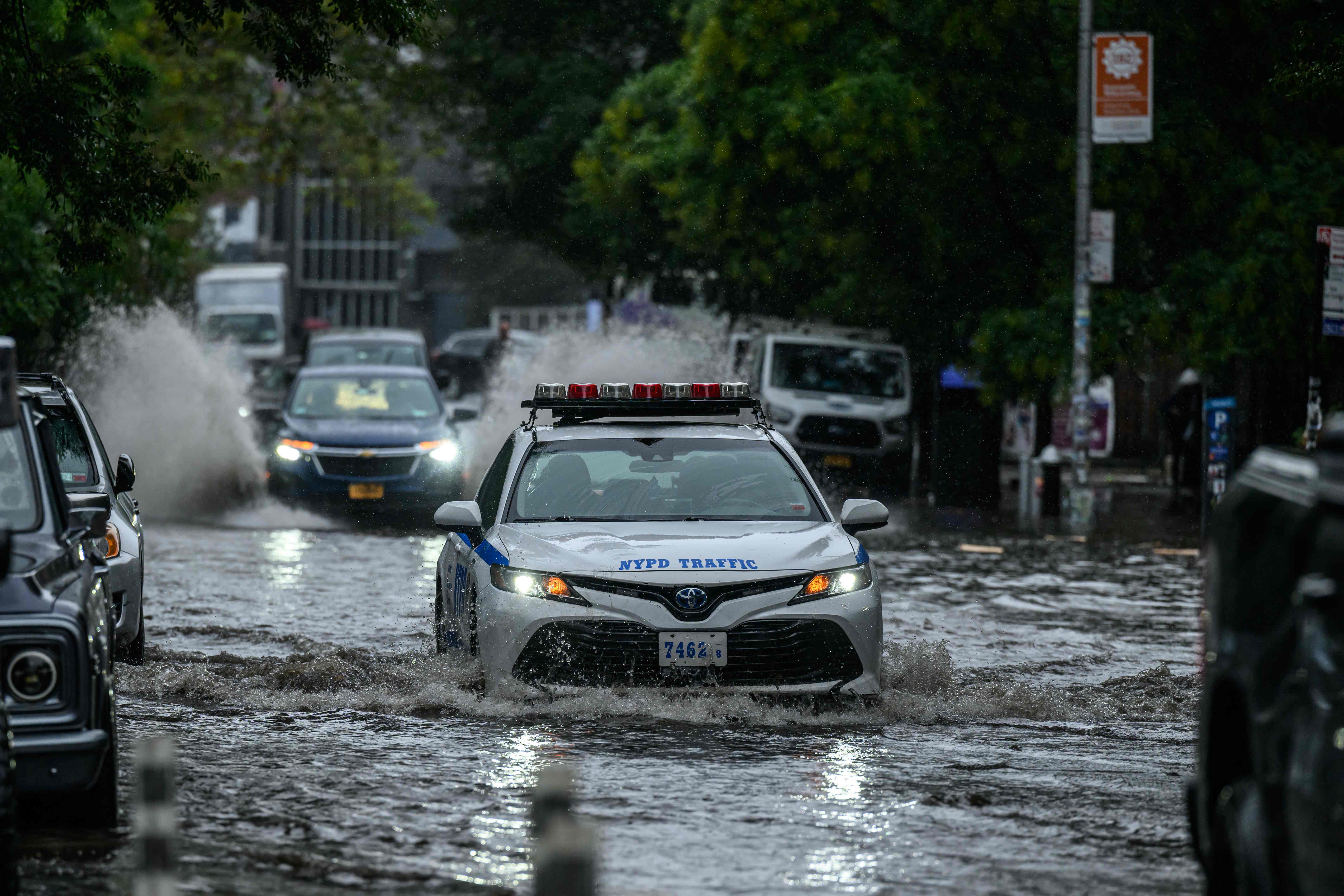 Sebuah mobil polisi berusaha menembus banjir di Brooklyn, New York, Amerika Serikat.