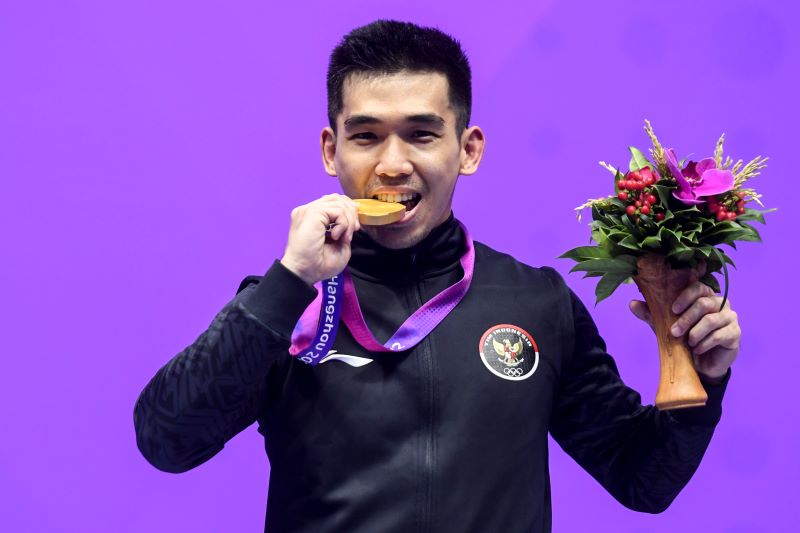  Pewushu Indonesia Harris Horatius menggigit medali emas usai juara di nomor nangun putra Asian Games 2022. 