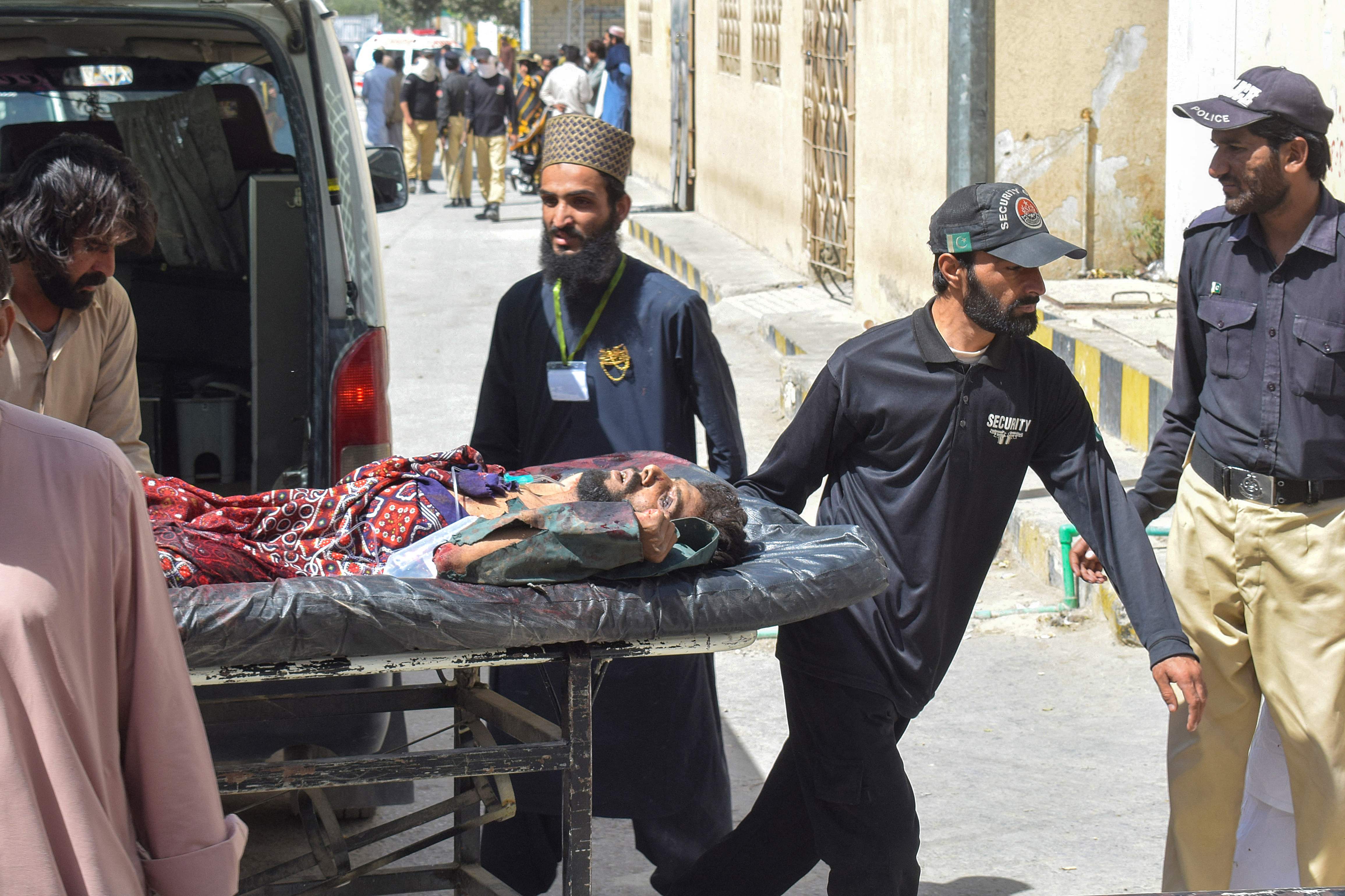 Petugas menurunkan korban serangan bom bunuh diri di Mastung, Pakistan.